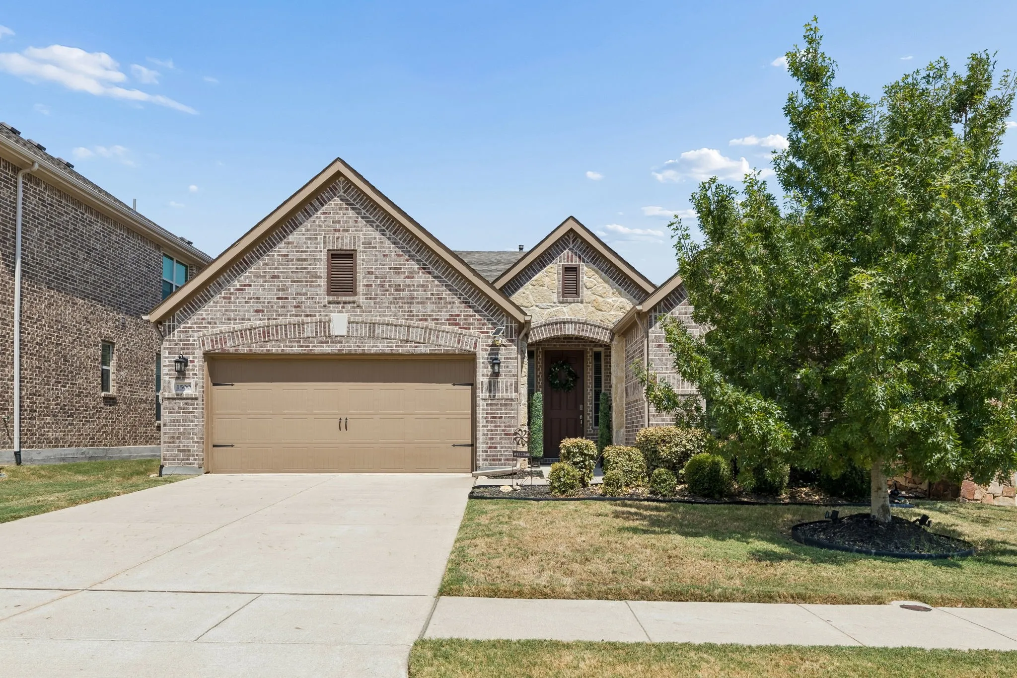 Brick and stone exterior with a gabled roofline and an arched entry