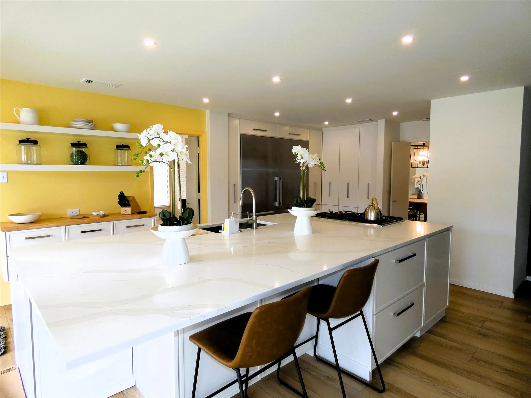 Kitchen with island seating and gas cooktop is open to the living area.