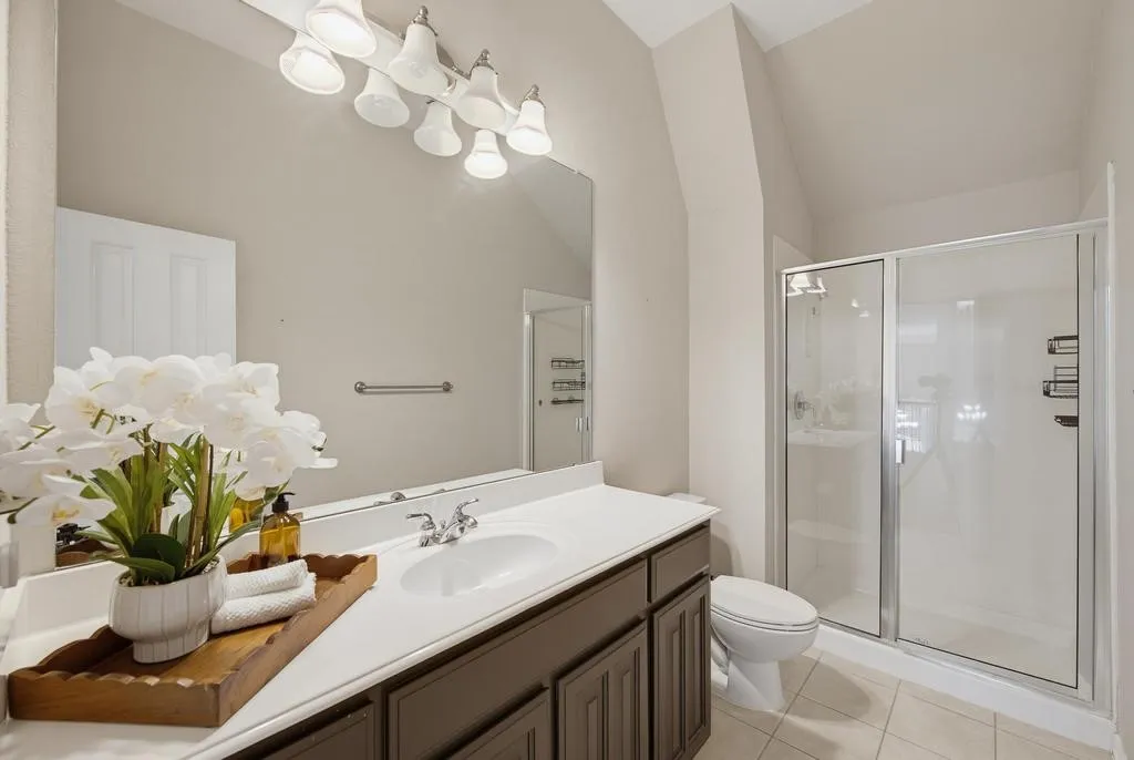 Vanity with an integrated sink, white countertop, and dark wood-finish cabinetry