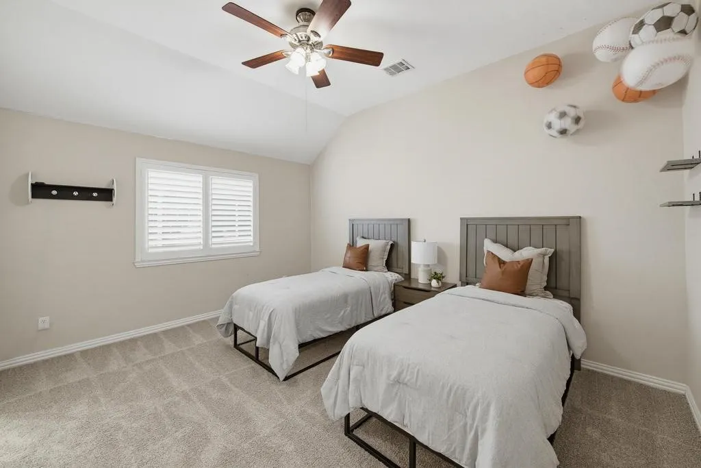 Vaulted ceiling with a ceiling fan, window with plantation shutters, and carpet flooring