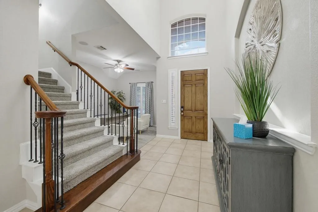 Two-story foyer with a wood-panel entry door and an arched transom window