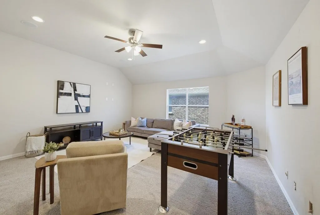 Vaulted ceiling with recessed lighting and a ceiling fan