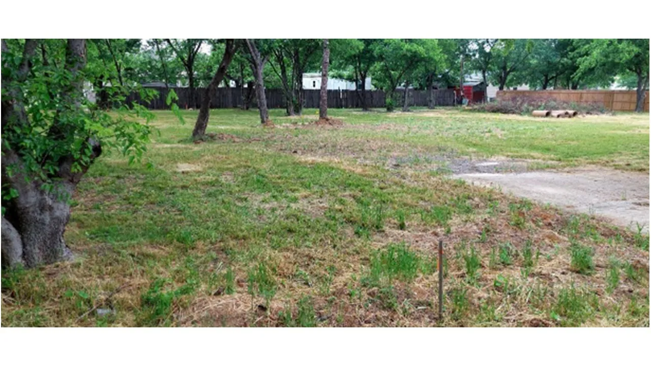 Expansive lot featuring mature trees and a perimeter privacy fence