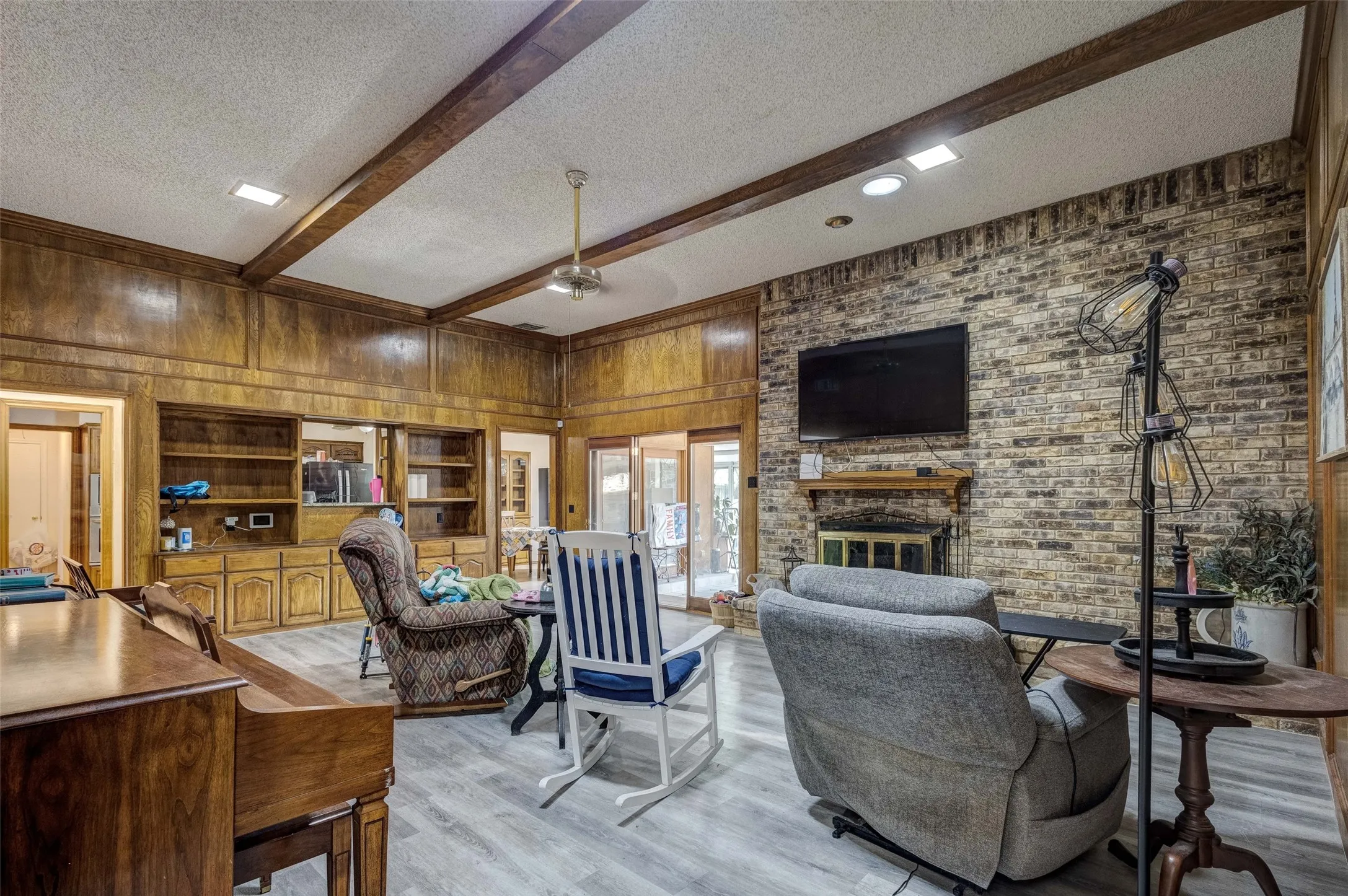 Brick accent wall with a fireplace and wood mantel