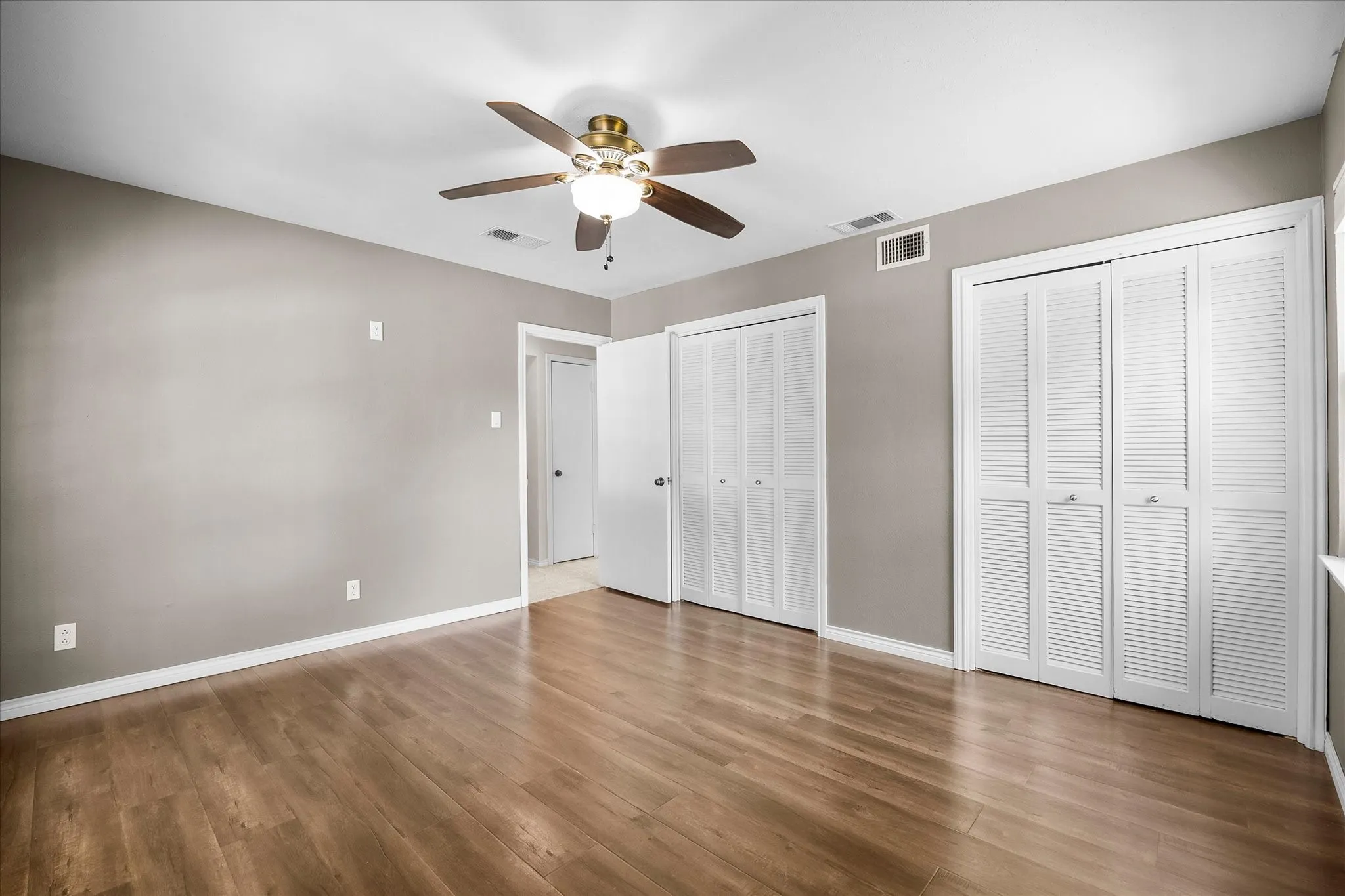 Spacious guest bedroom includes his and her closets