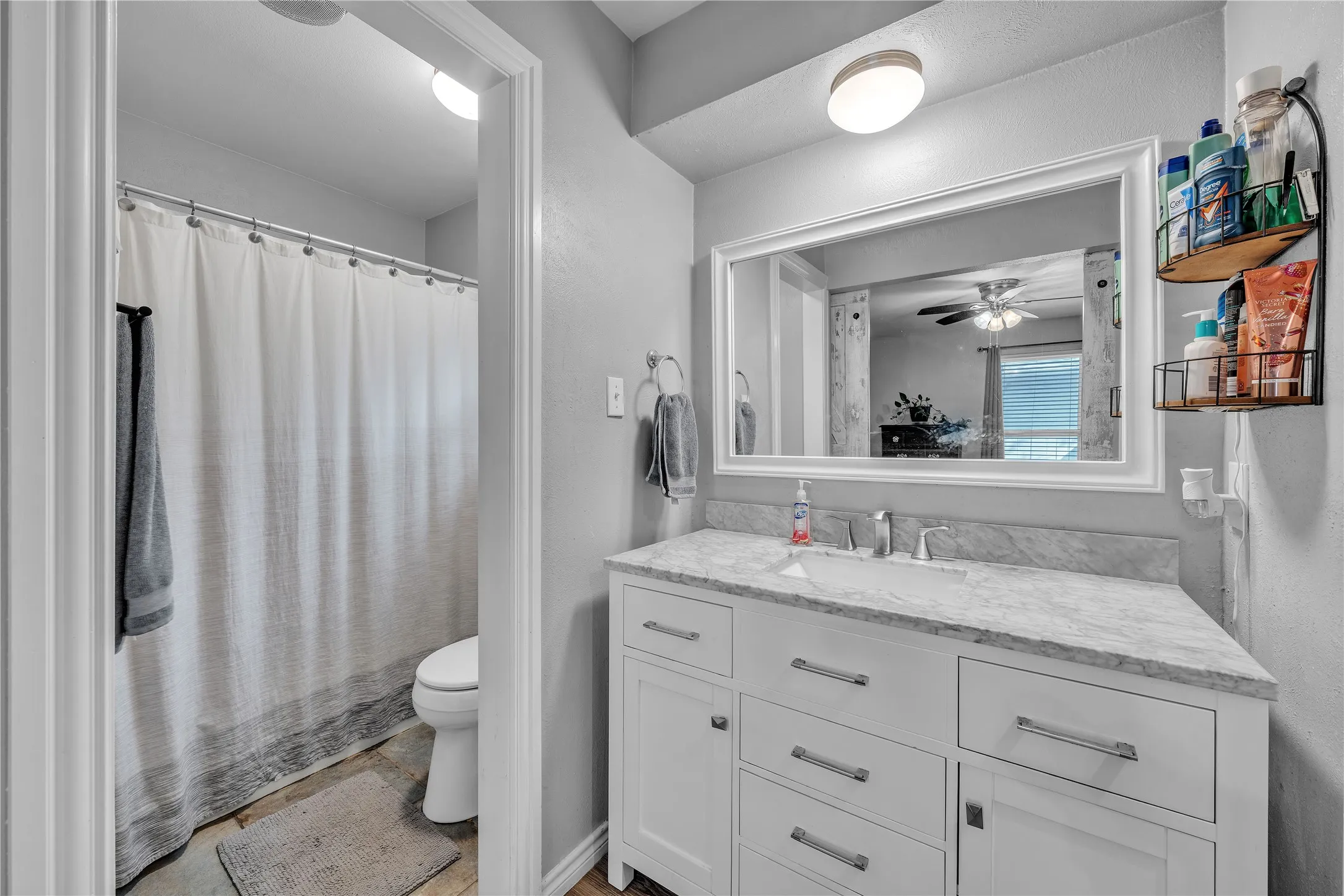 White vanity with brushed nickel hardware, undermount sink, and stone countertop