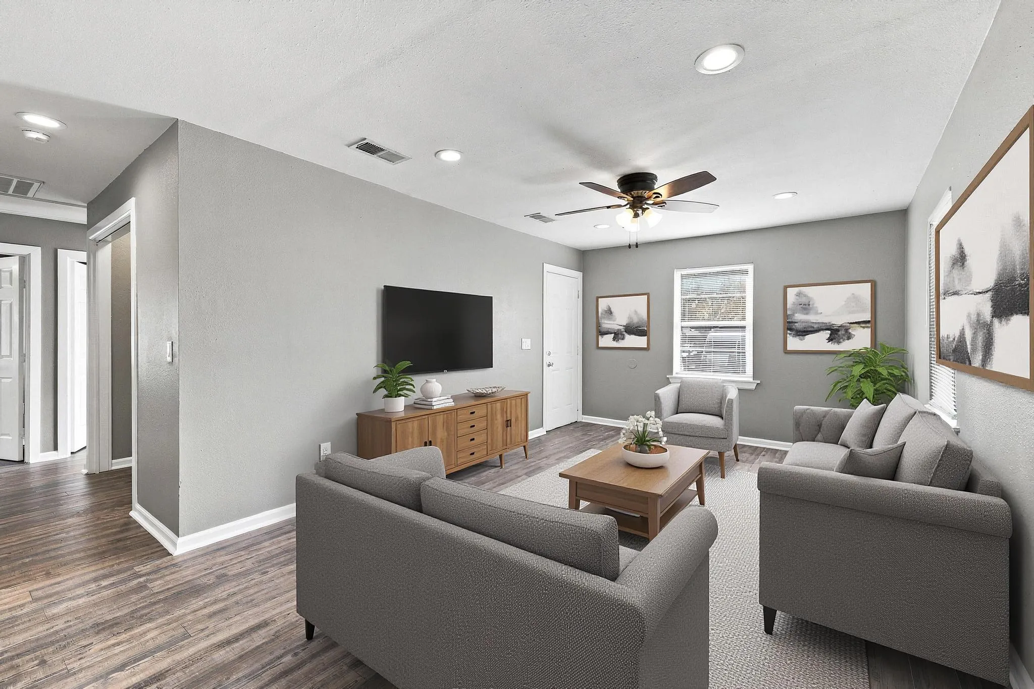 Spacious living area featuring wood-finish flooring, recessed lighting, and a ceiling fan