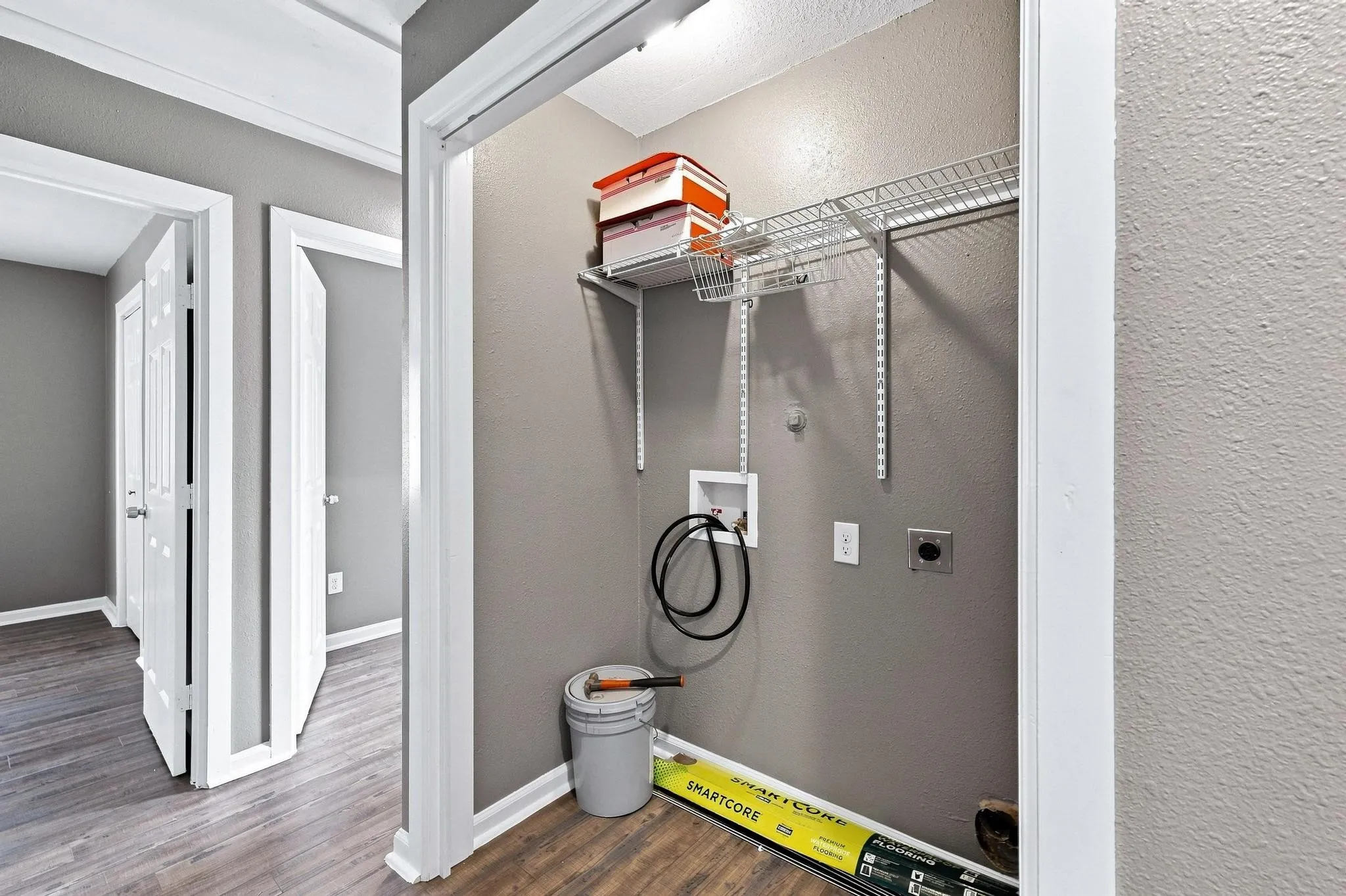 Utility area with wire shelving and wood-finish flooring