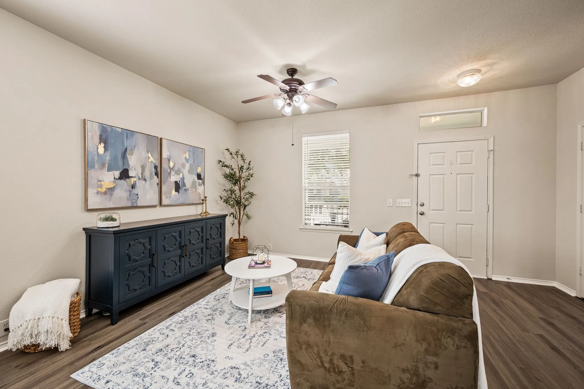 Wood-finish flooring throughout, ceiling fan with integrated lighting, recessed overhead lighting, and a transom window above the entry door