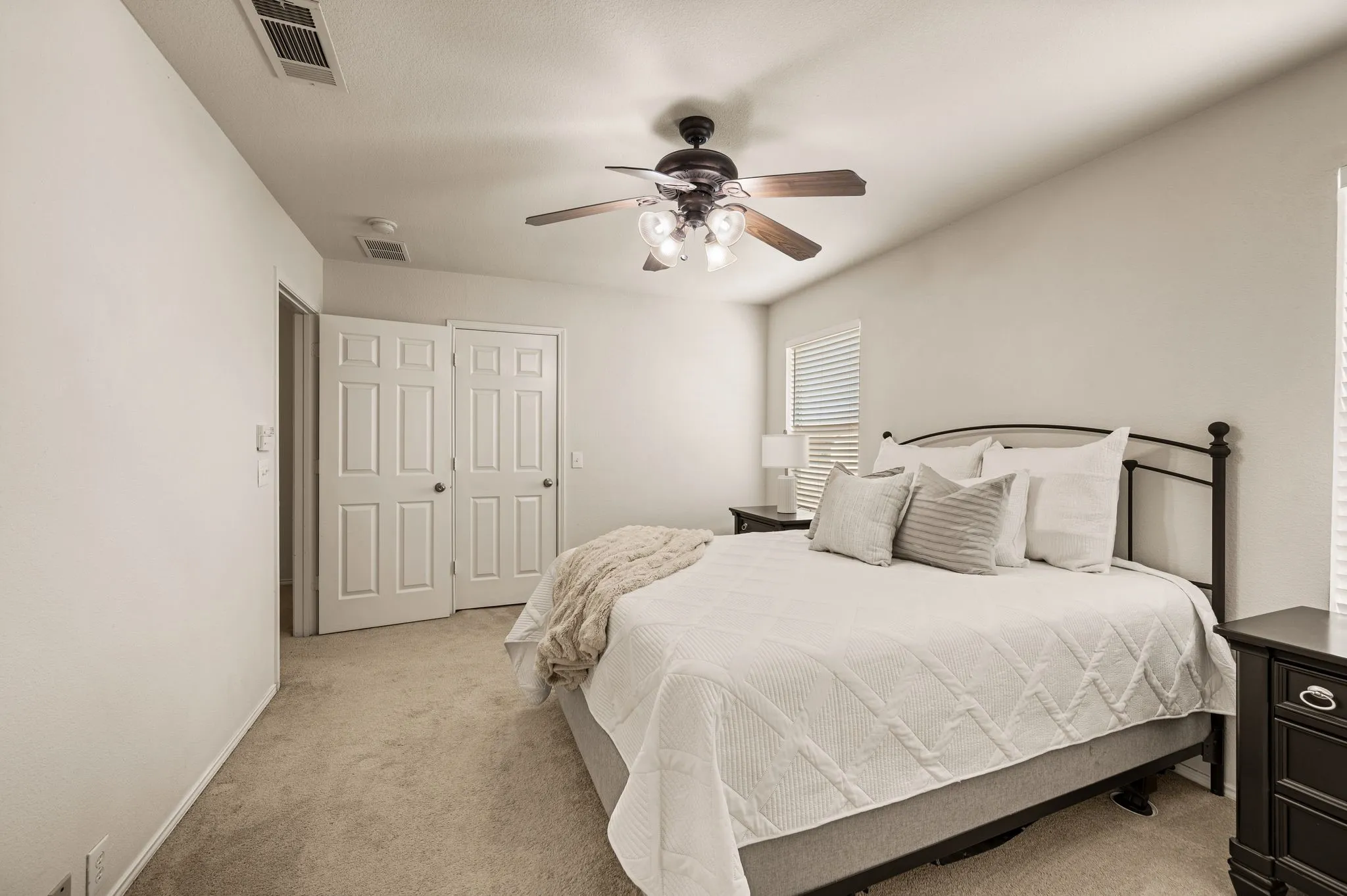 Vaulted ceiling with a ceiling fan, carpeted flooring, window with horizontal blinds, and paneled bifold closet doors