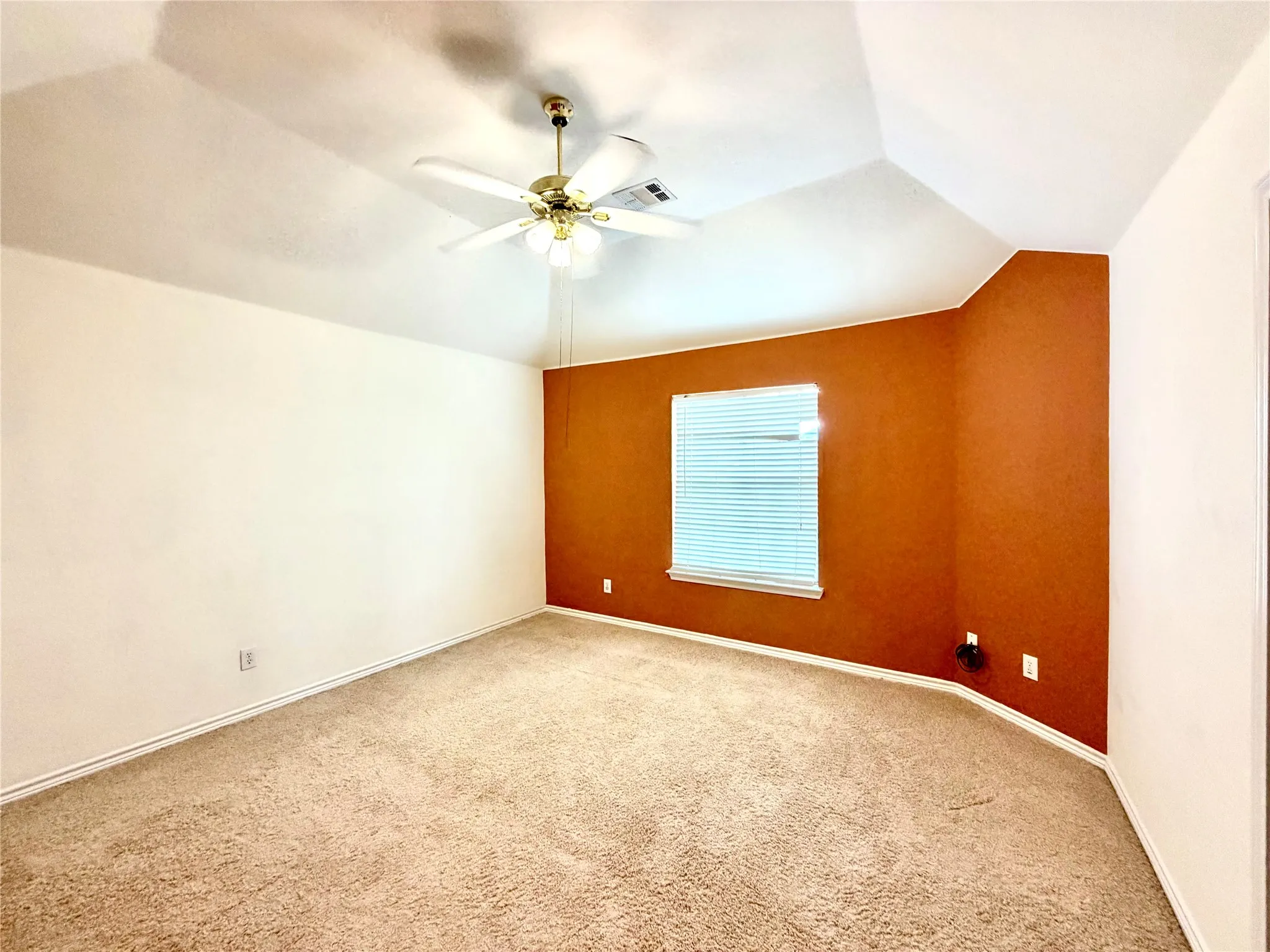 Vaulted ceiling with a ceiling fan, carpeted flooring, and a window with blinds