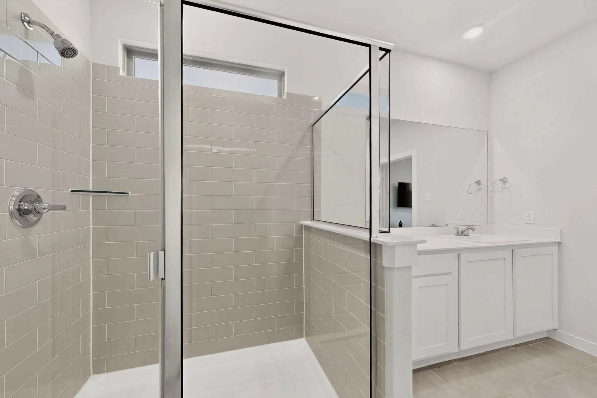 Walk-in shower with subway tile surround, glass enclosure, and chrome fixtures