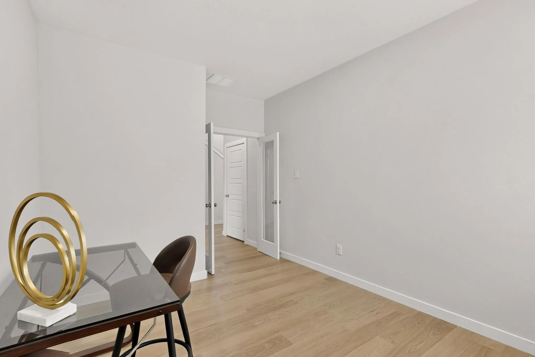 Wood-finish flooring, white baseboards, and white walls