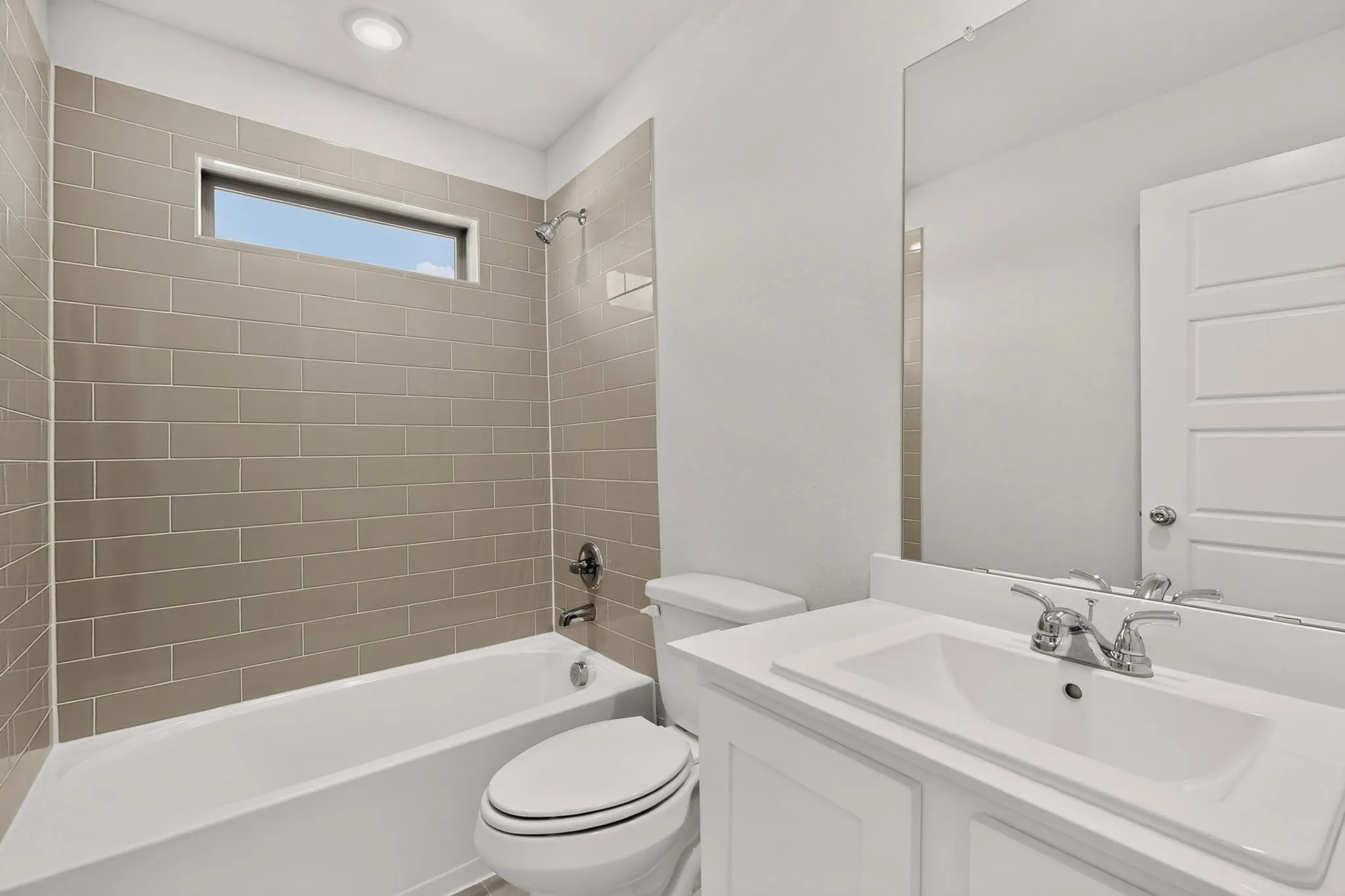 Bathroom featuring a vanity with an integrated sink, polished chrome faucet, and full-width mirror
