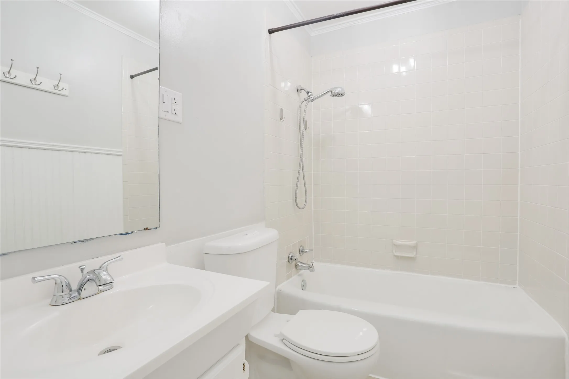 White subway tile shower surround with a fixed showerhead and handheld sprayer
