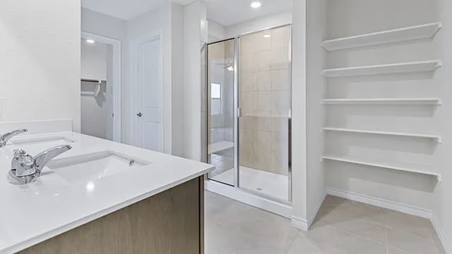 Full bathroom with recessed lighting, baseboards, tile patterned flooring, and a stall shower