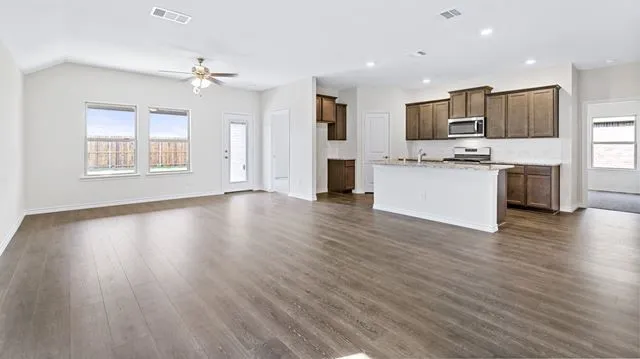 Kitchen with stainless steel microwave, visible vents, open floor plan, and range