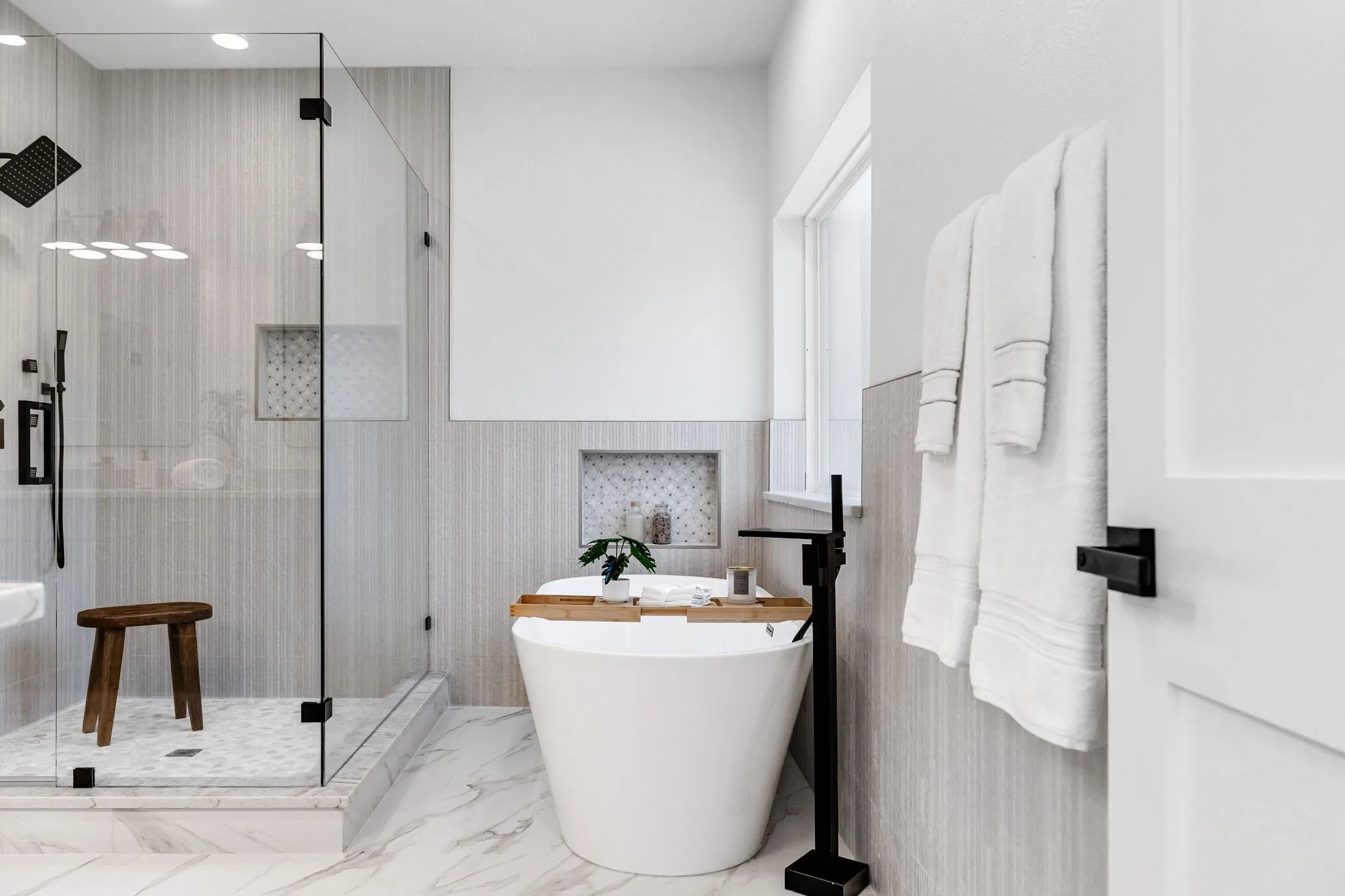4402 Briargrove-Freestanding soaking tub paired with a sleek floor-mounted matte black faucet.