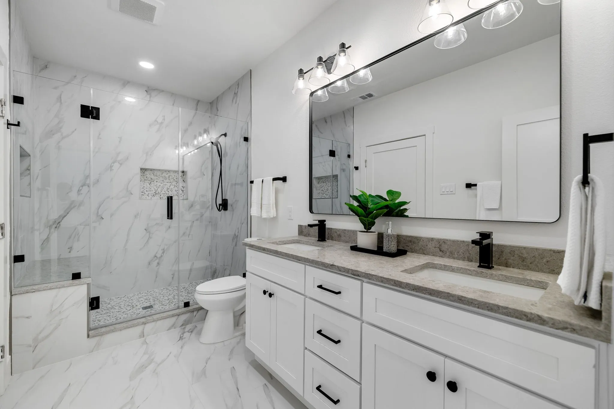 4402 Briargrove-Dual sink vanity with stone countertop, large rectangular mirror, and matte black fixtures