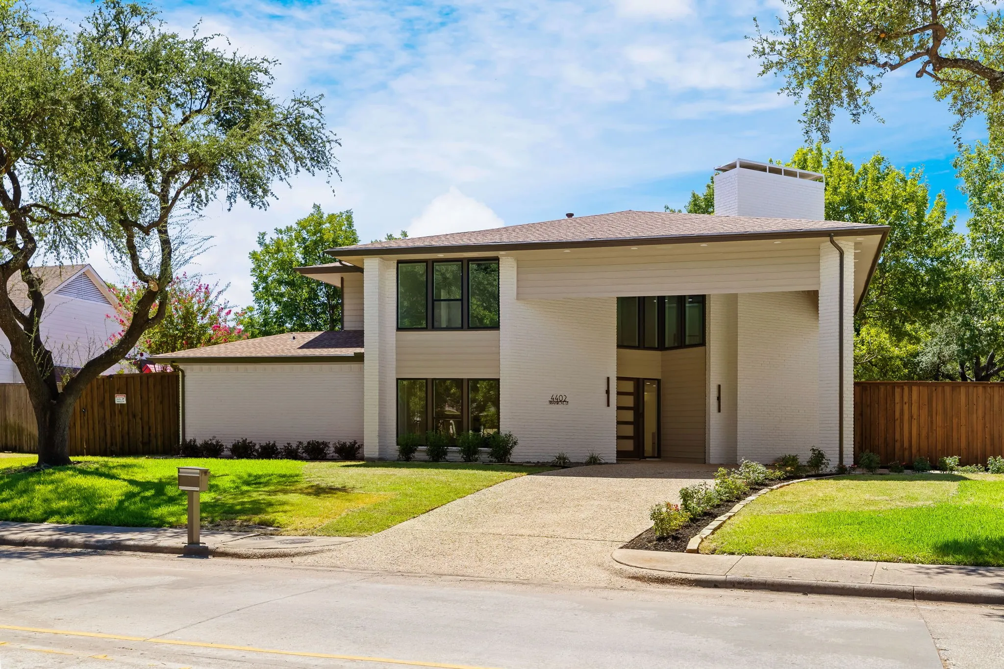 4402 Briargrove-Transitional modern architecture with white brick and warm wood accents.