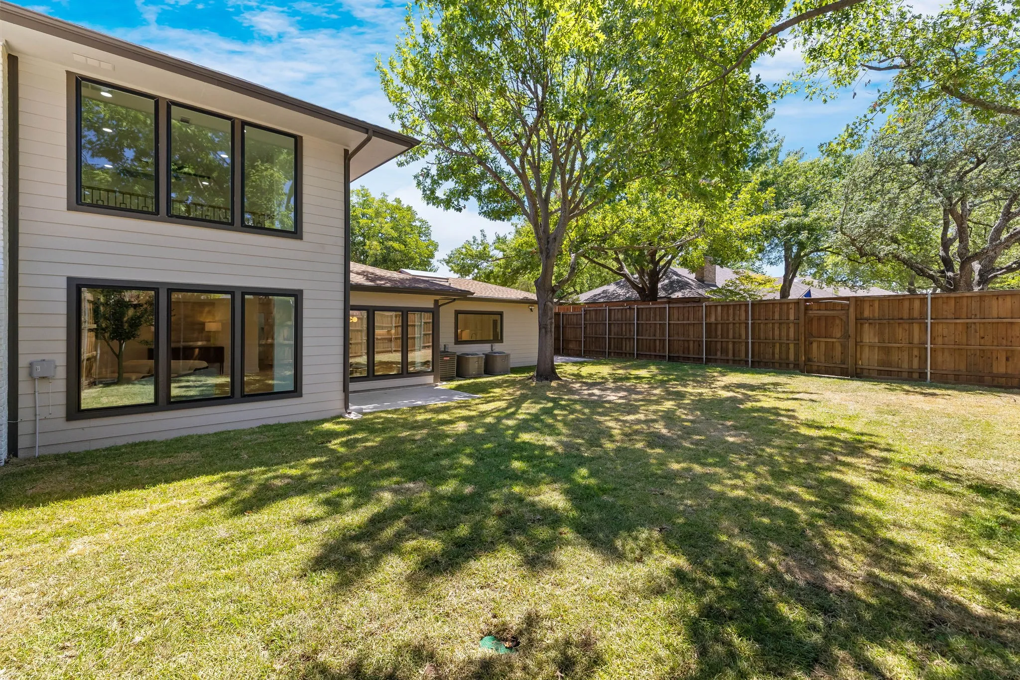 4402 Briargrove-Expansive grass lawn with mature trees, a privacy fence, and a patio