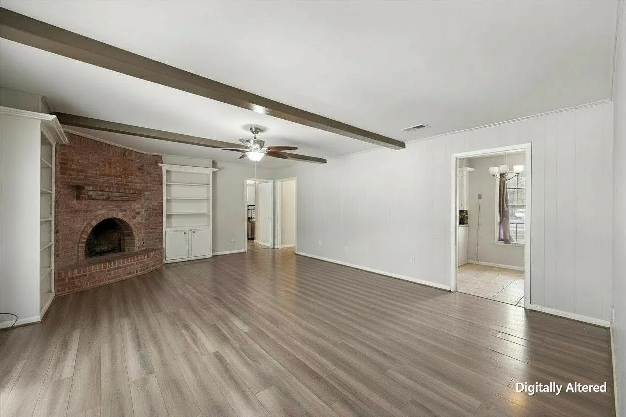 Empty living and dining area provides a clear look at the home's generous floor space, neutral finishes, ceiling fan, and brick fireplace.
