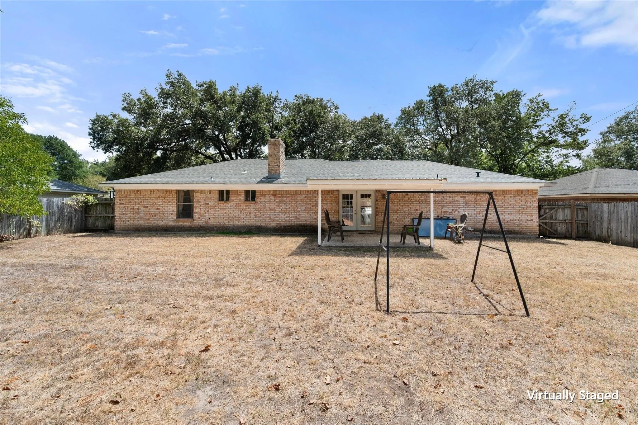 Large fenced backyard offers substantial outdoor space behind the single-story brick home, adding tenant-friendly usability and privacy.
