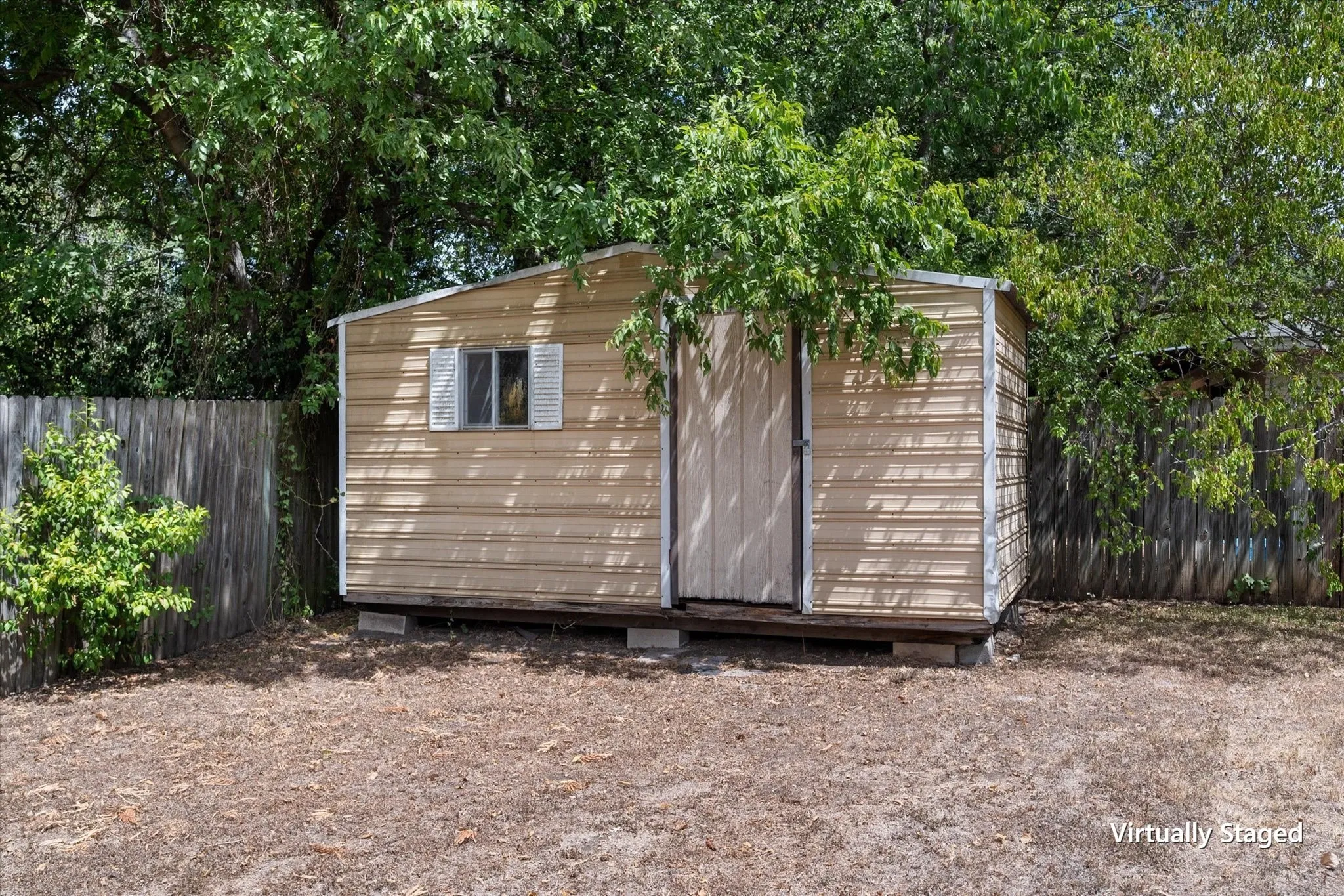 Detached storage shed provides useful additional storage in the fenced backyard, a practical feature for tenants or property owners.