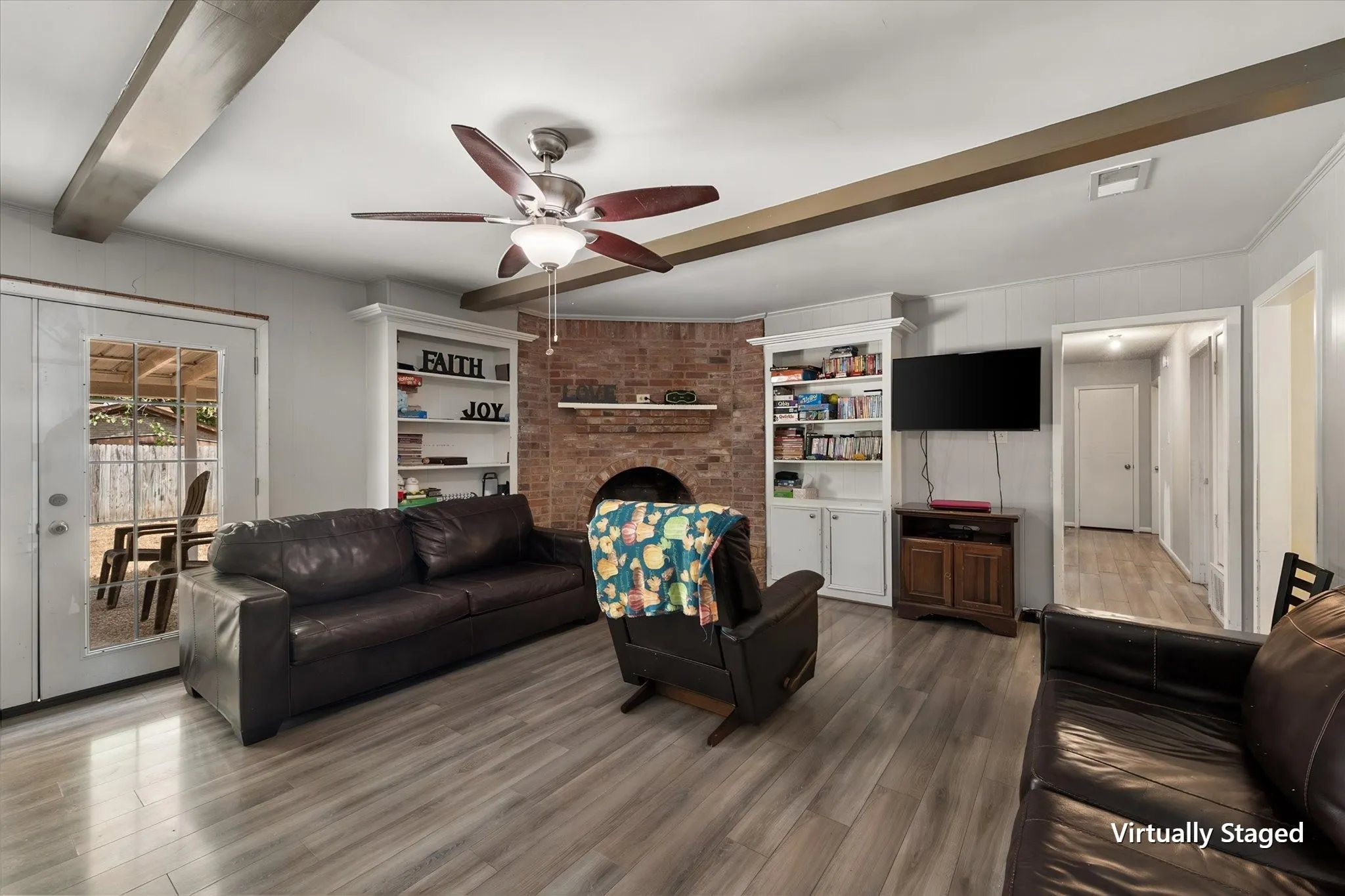 Spacious living and dining area highlights the home's open gathering space, durable hard-surface flooring, ceiling fan, and flexible layout.