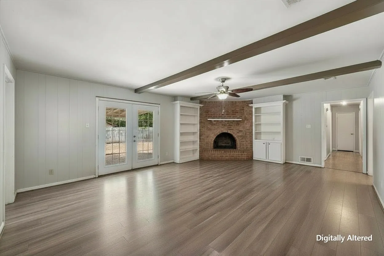 Alternate living-room view highlights the home's spacious interior, luxury vinyl plank flooring, brick fireplace, and flexible furniture arrangement.