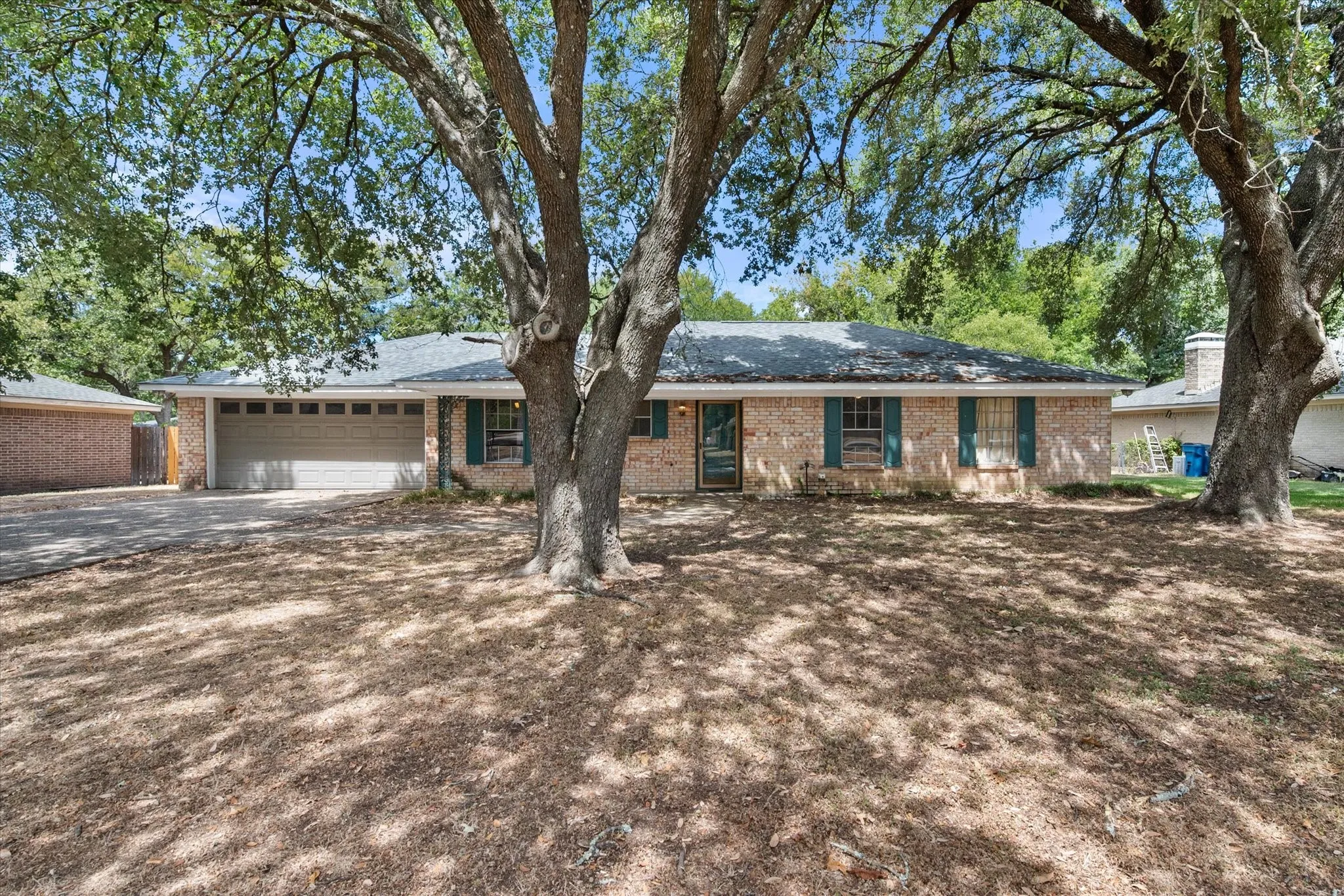 Single-story brick exterior and mature tree canopy create an established residential appearance for this Corsicana TX rental property.