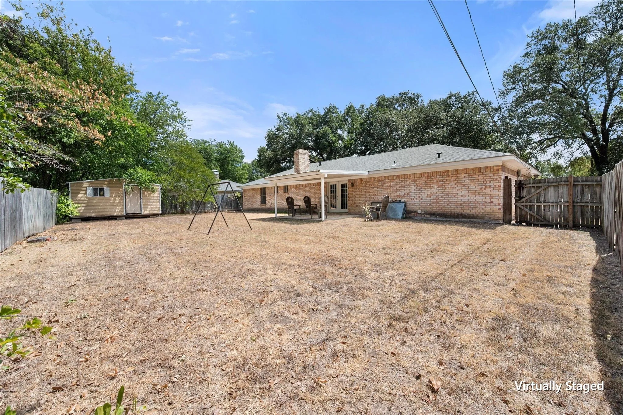 Wide backyard perspective highlights the private fenced lot and ample outdoor area accompanying this Corsicana rental investment property.