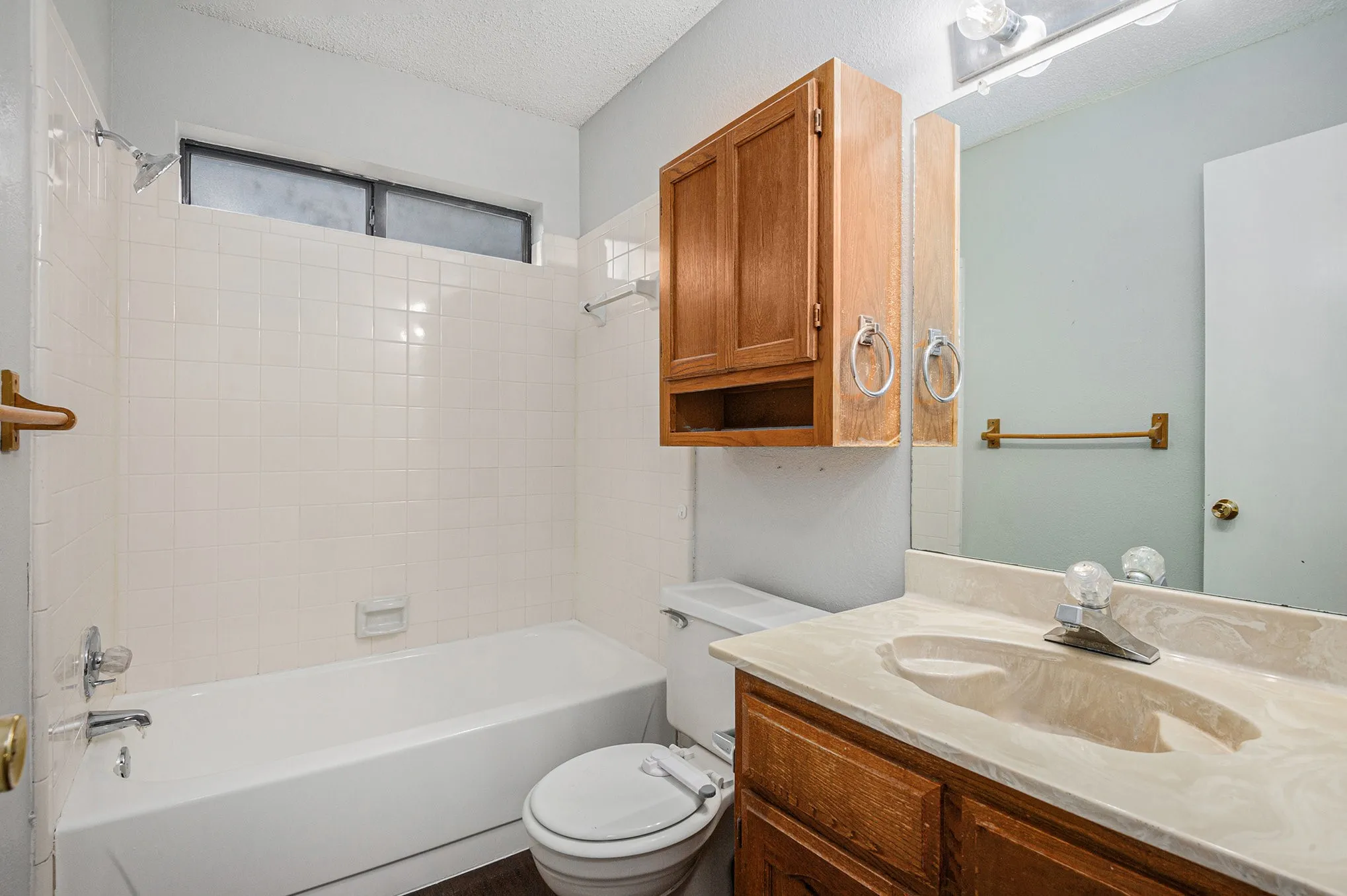 Bathroom featuring a built-in vanity with an integrated sink and a wood-finish cabinet