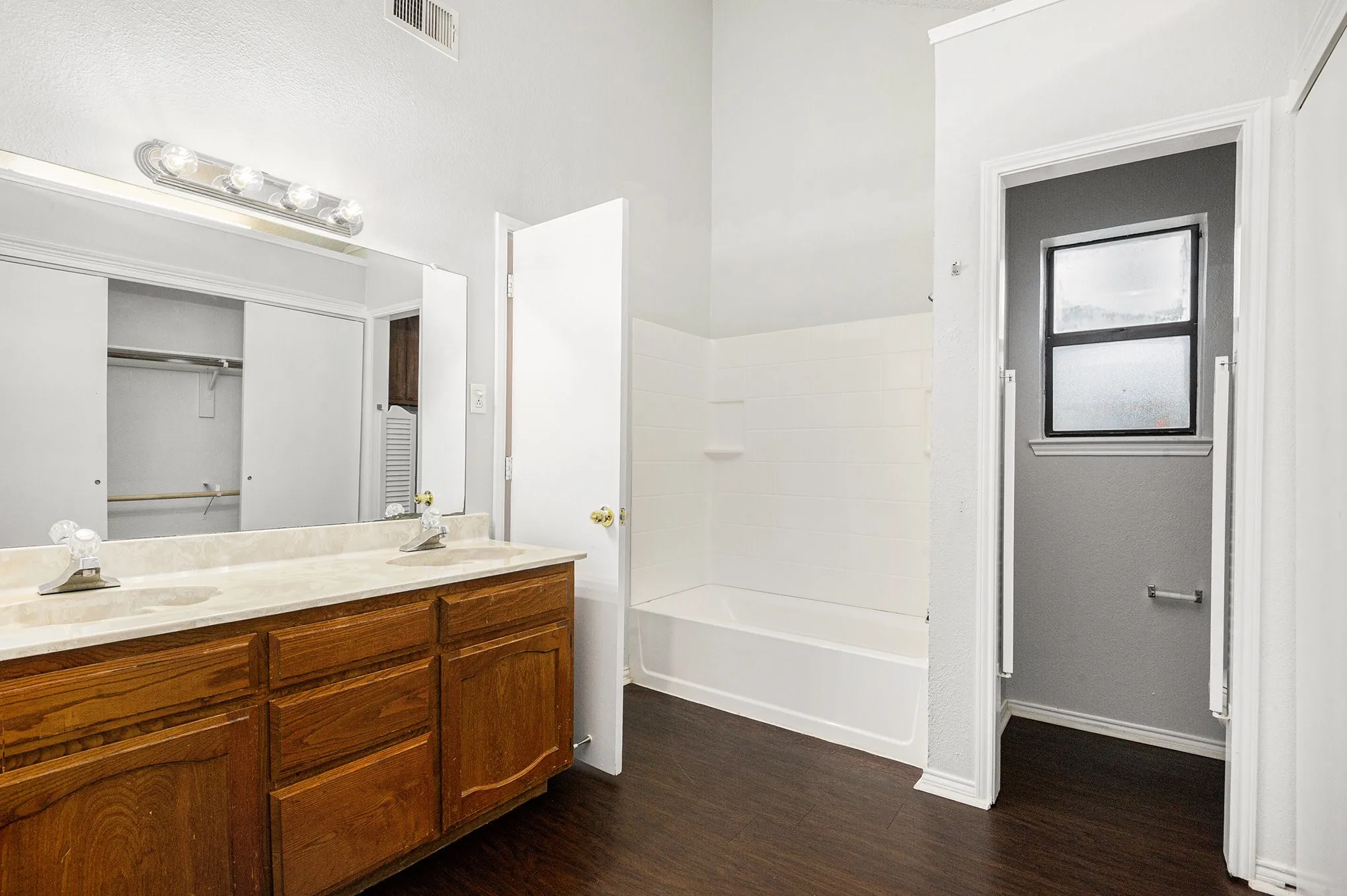 Double vanity with wood cabinetry and a light-colored countertop