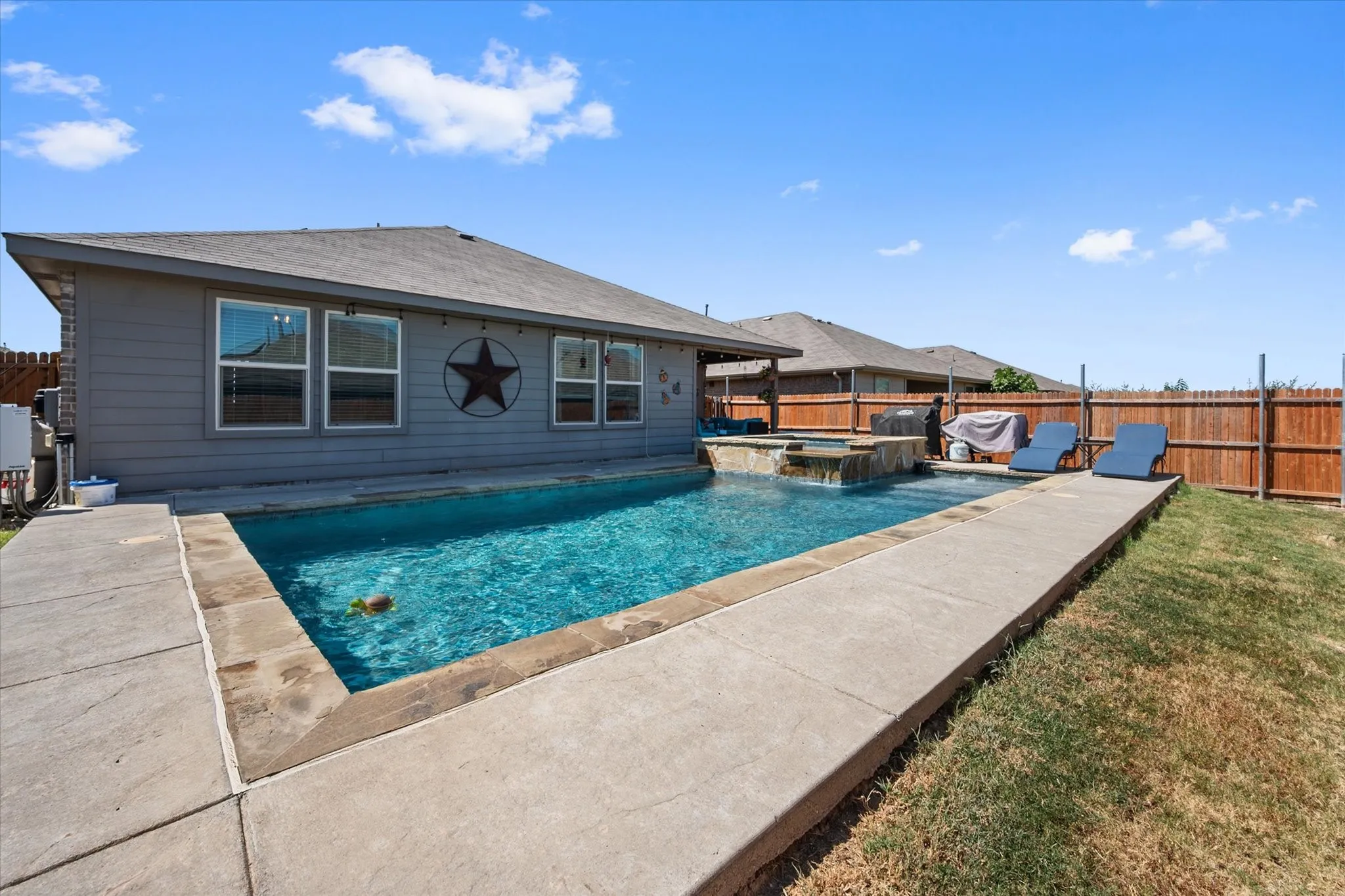 Rectangular swimming pool with integrated spa and water feature