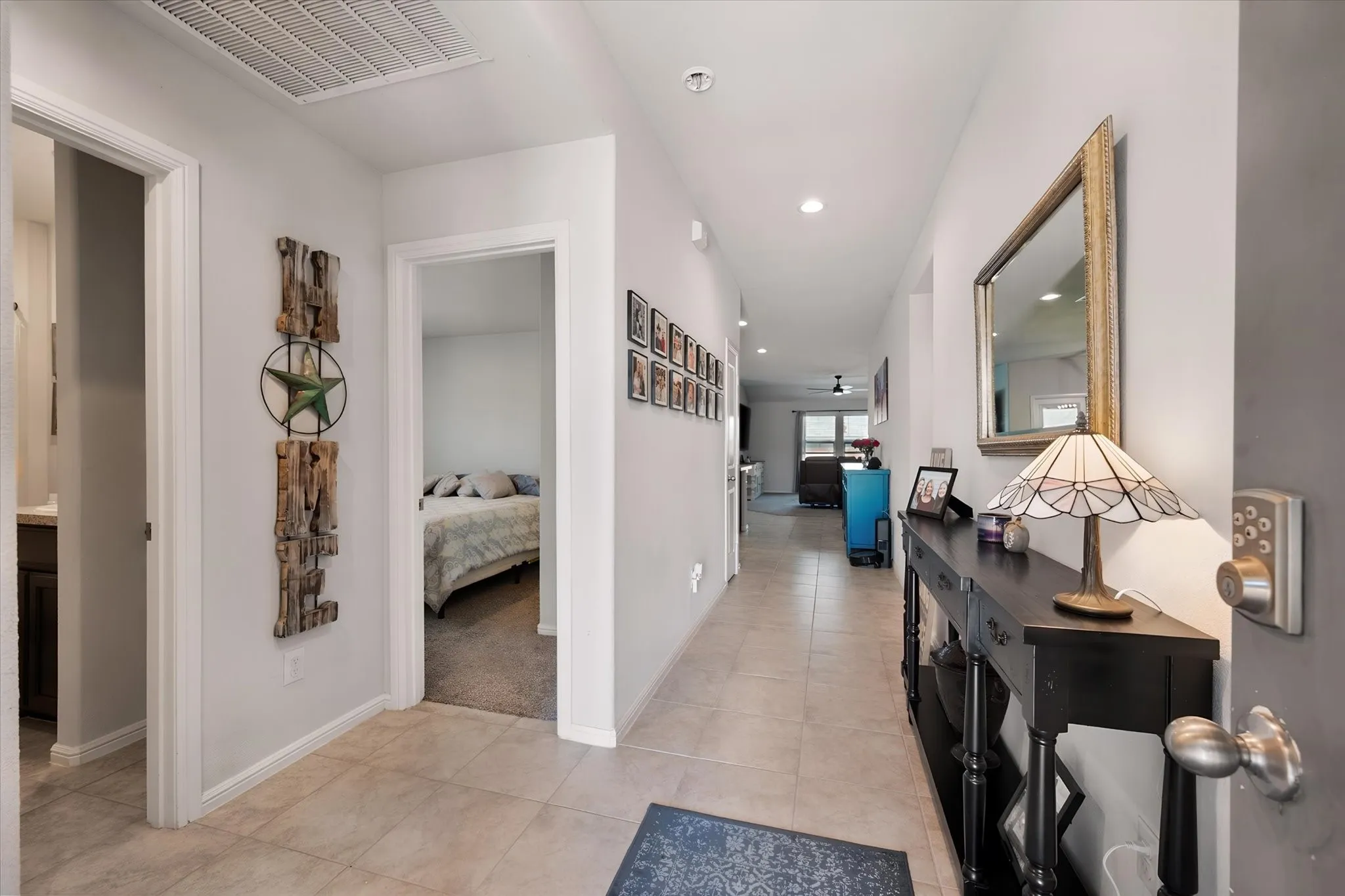 Recessed lighting, tile flooring, and white trim throughout the entry hallway