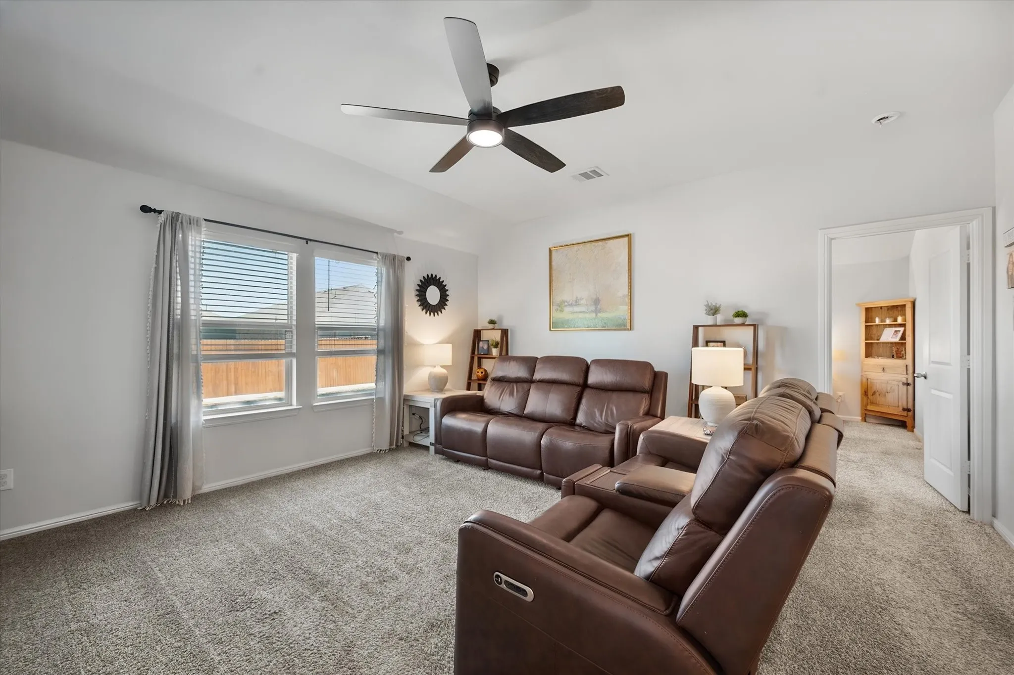 Living area features a ceiling fan with integrated lighting and views of the backyard pool area!