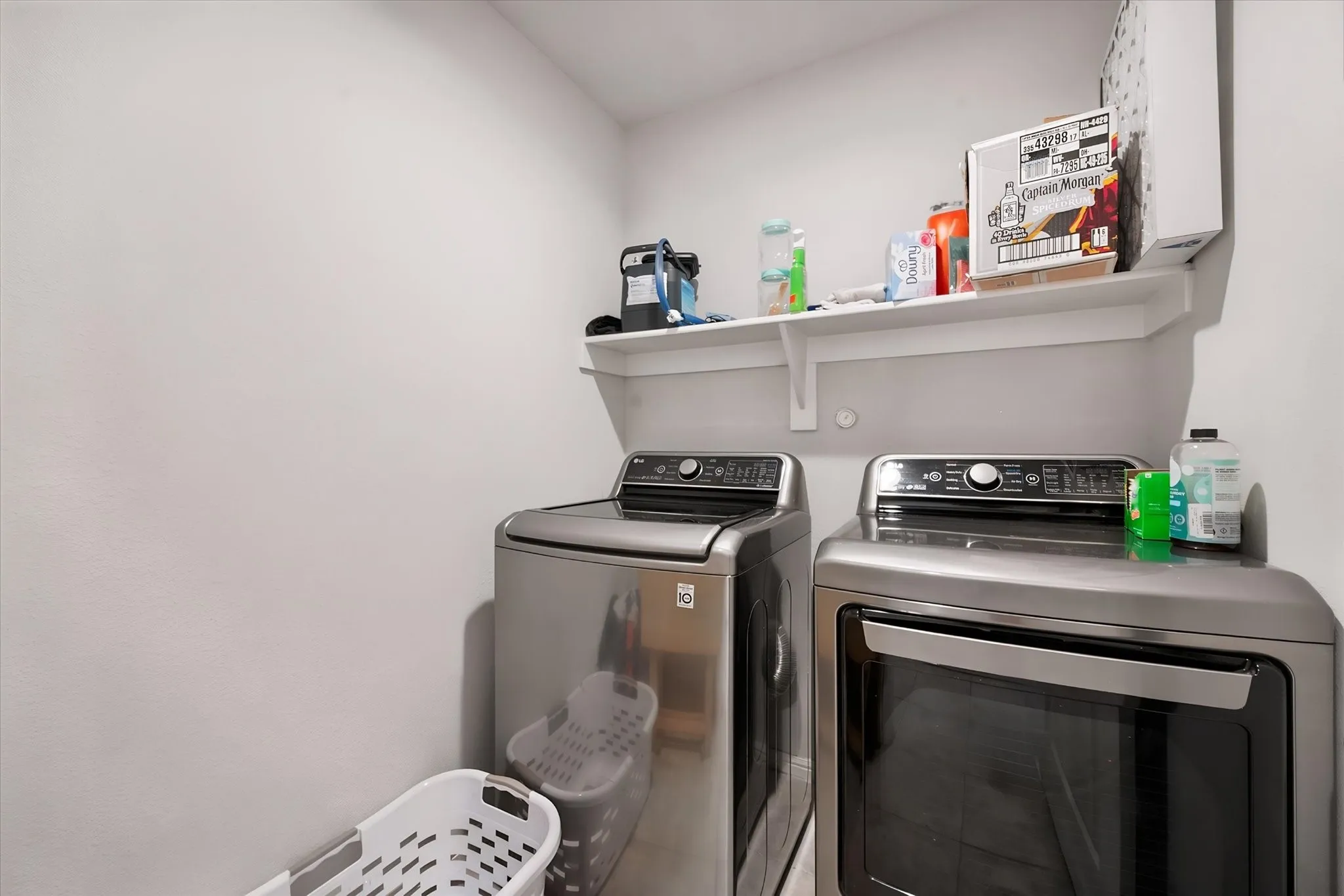 Laundry area featuring a wall-mounted shelf