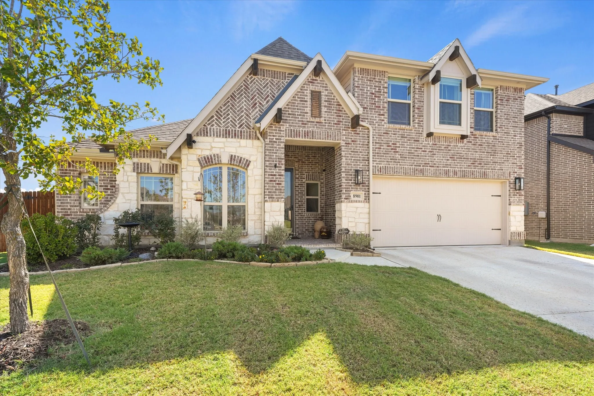Landscaped front yard and upgraded brick-and-stone exterior at 8901 Caymen St in Country Lakes, a master-planned community near Argyle and south Denton with neighborhood pools, trails, parks, playgrounds, and ponds.