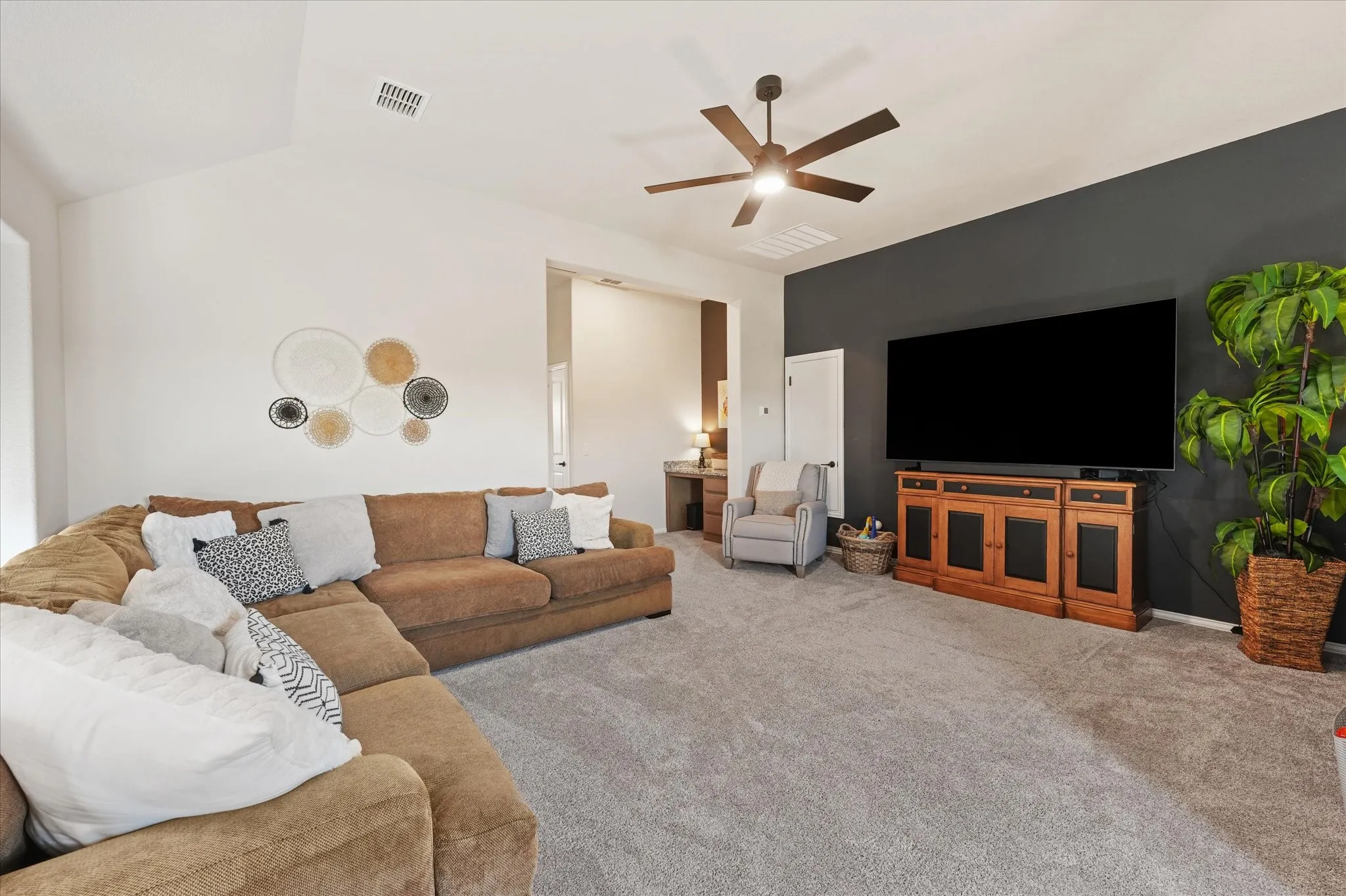 Large upstairs game room or second living area with vaulted ceiling, ceiling fan, and plenty of space for a sectional, media setup, playroom, or entertainment area.