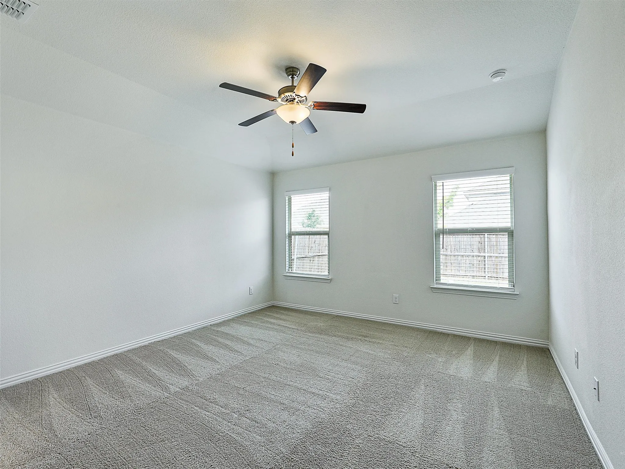 Primary bedroom with windows to back yard