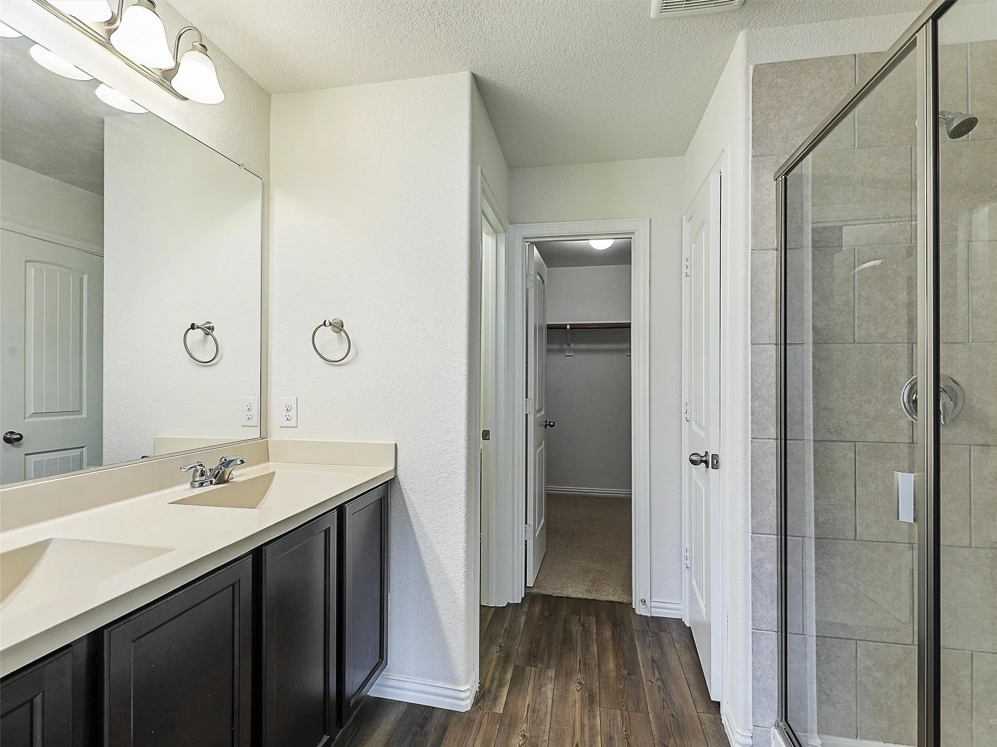 Primary bath room with dual sinks and large mirror
