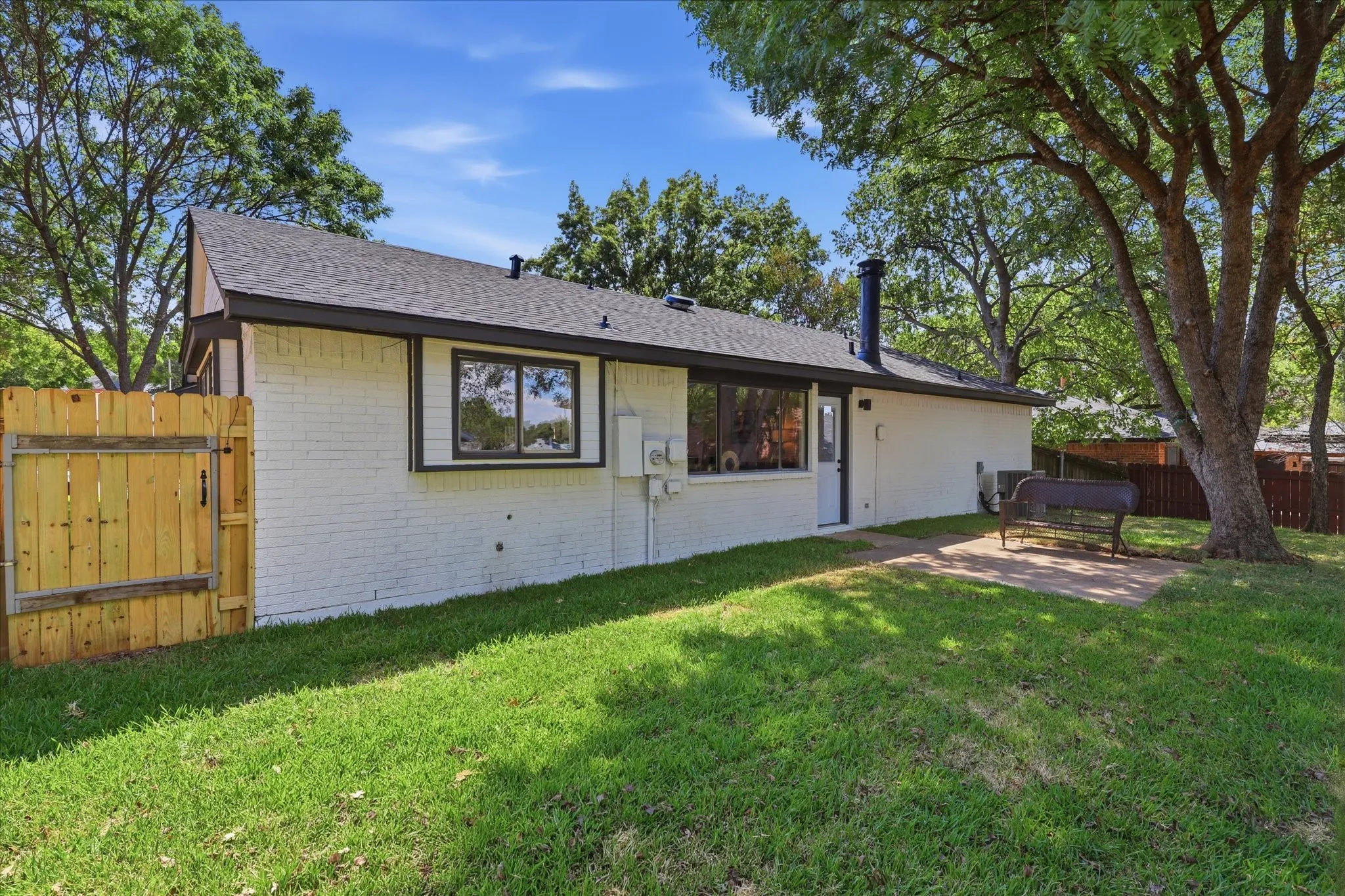 White painted brick exterior with black trim and a dark shingle roof