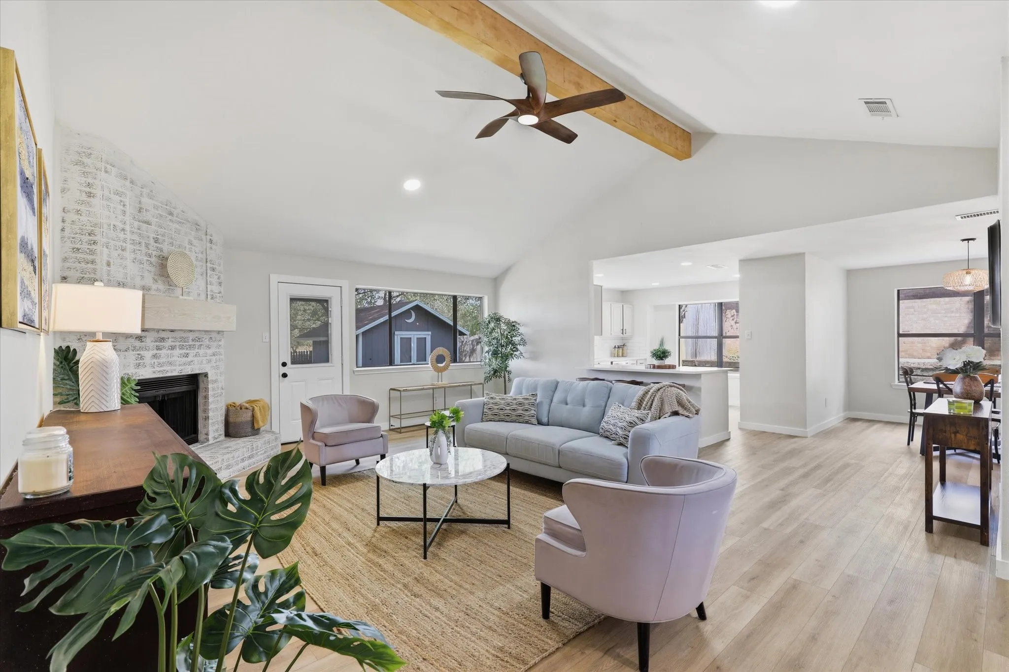 Vaulted ceiling with exposed wood beam, recessed lighting, and a ceiling fan