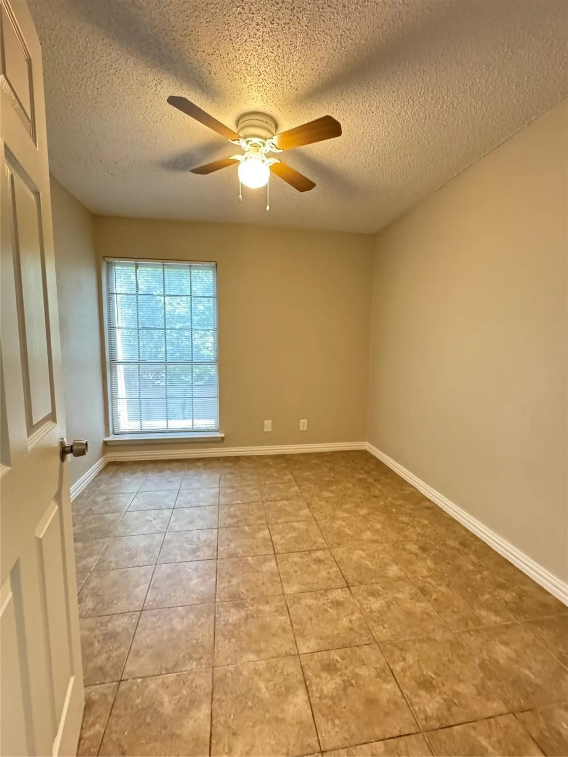 Tile flooring, ceiling fan with light, single window, painted walls, white trim