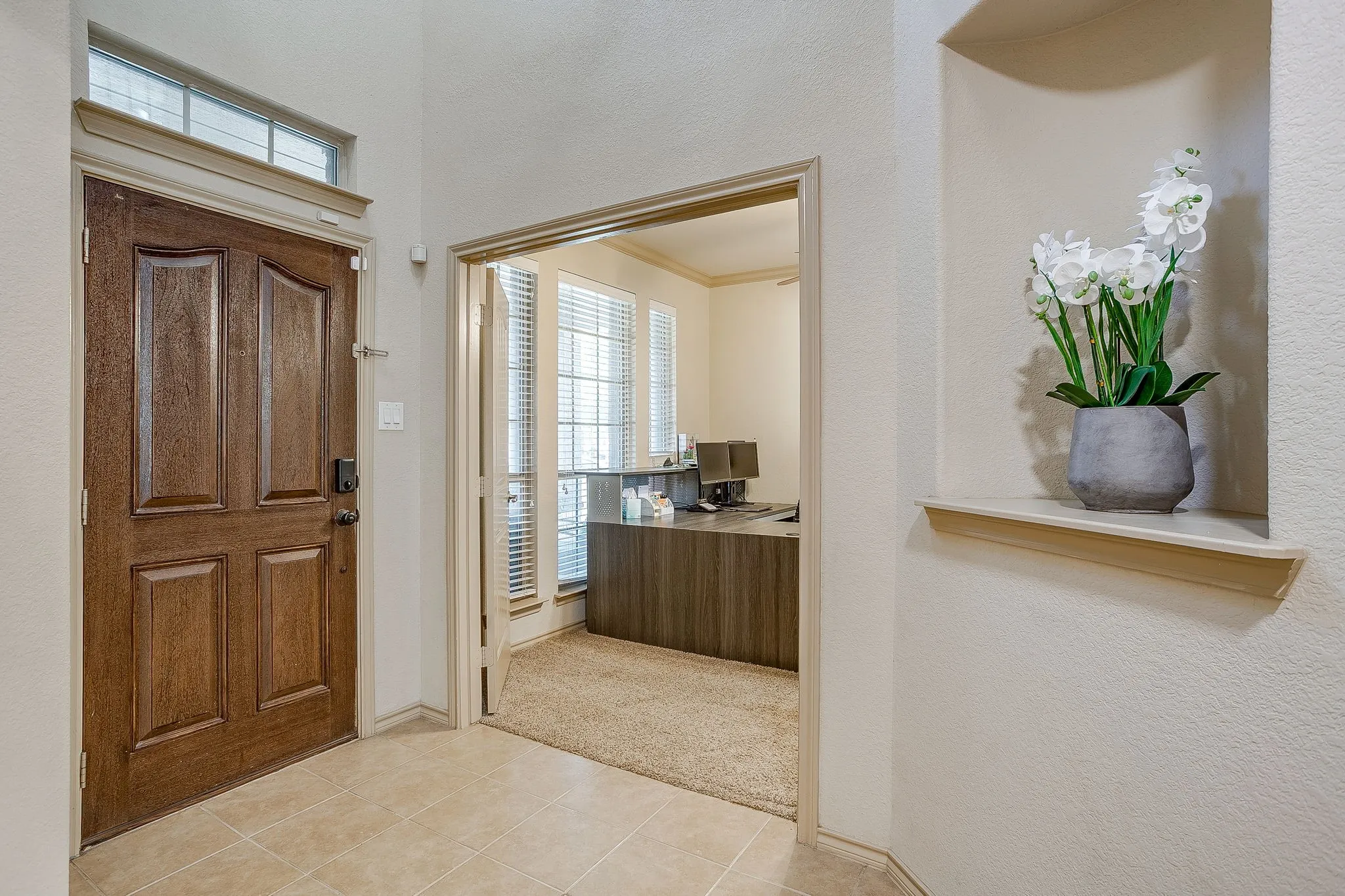 Great foyer with high ceilings, chandelier, decorative niche and home office with double doors.
