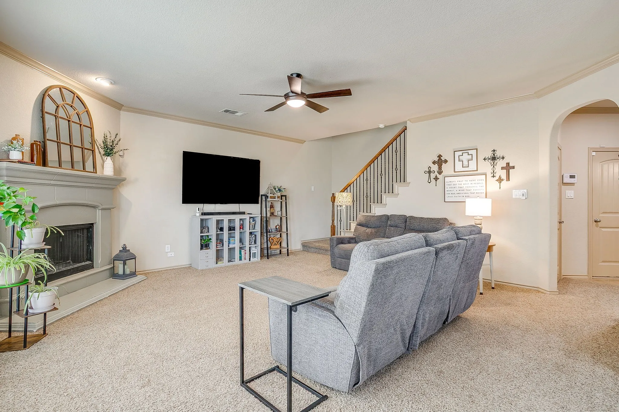 Large family room with wood burning FP and ceiling fan.