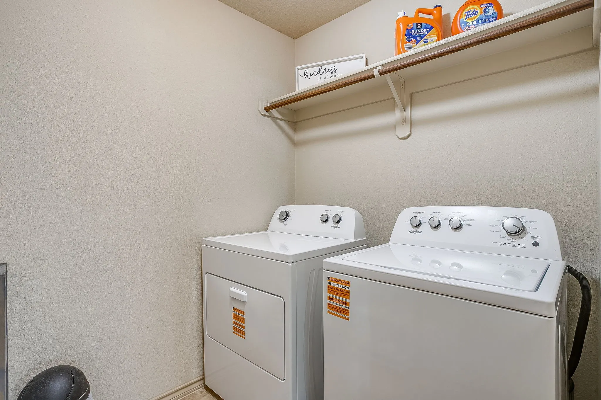 Upstairs laundry room with washer and dryer hookups, hanging space and built in shelf.