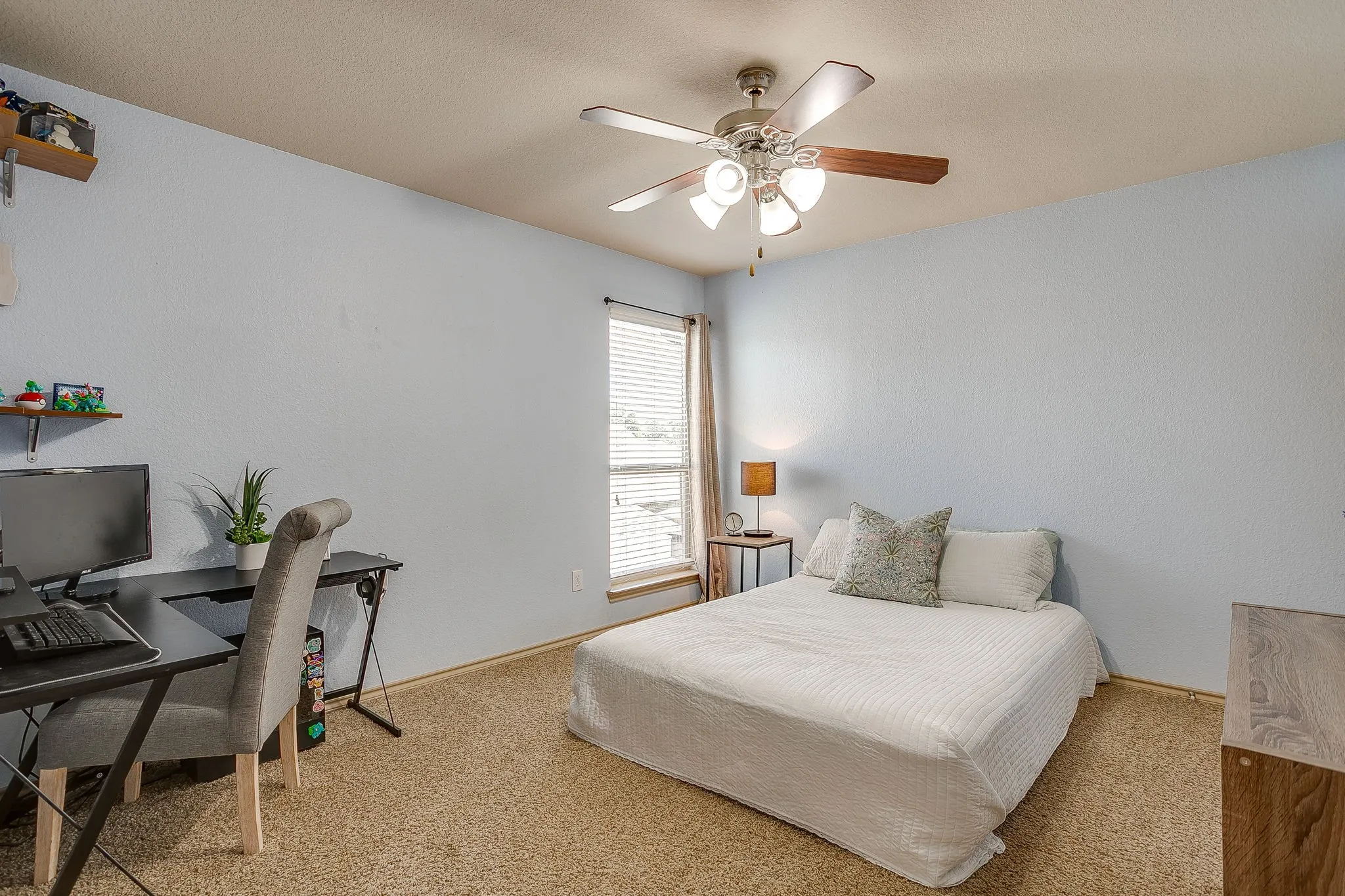 Upstairs bedroom 4 with corner window, carpet and fan.  Neutral paint.