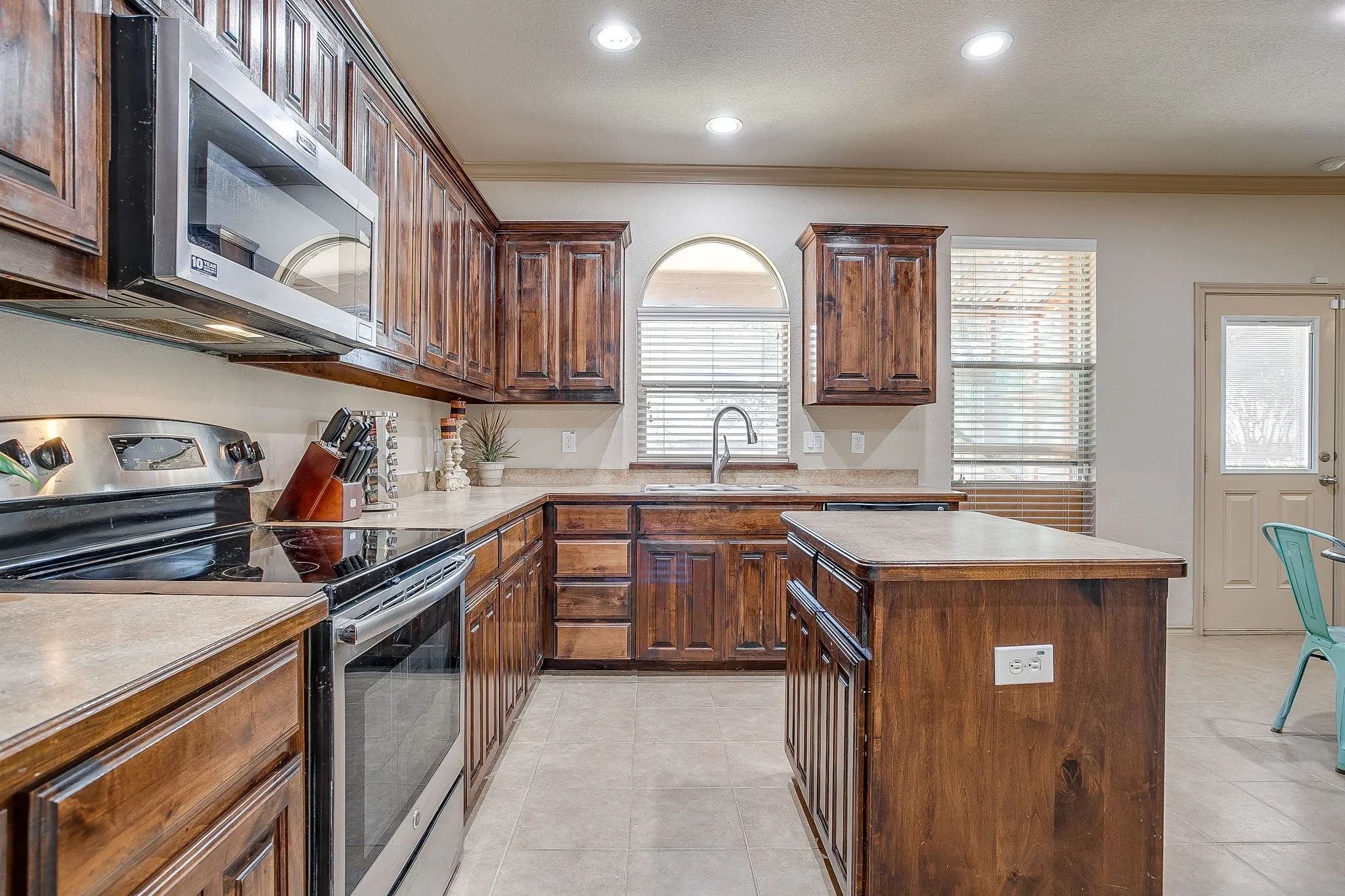 Electric cooking and window over sink. Stainless Steel Appliances.